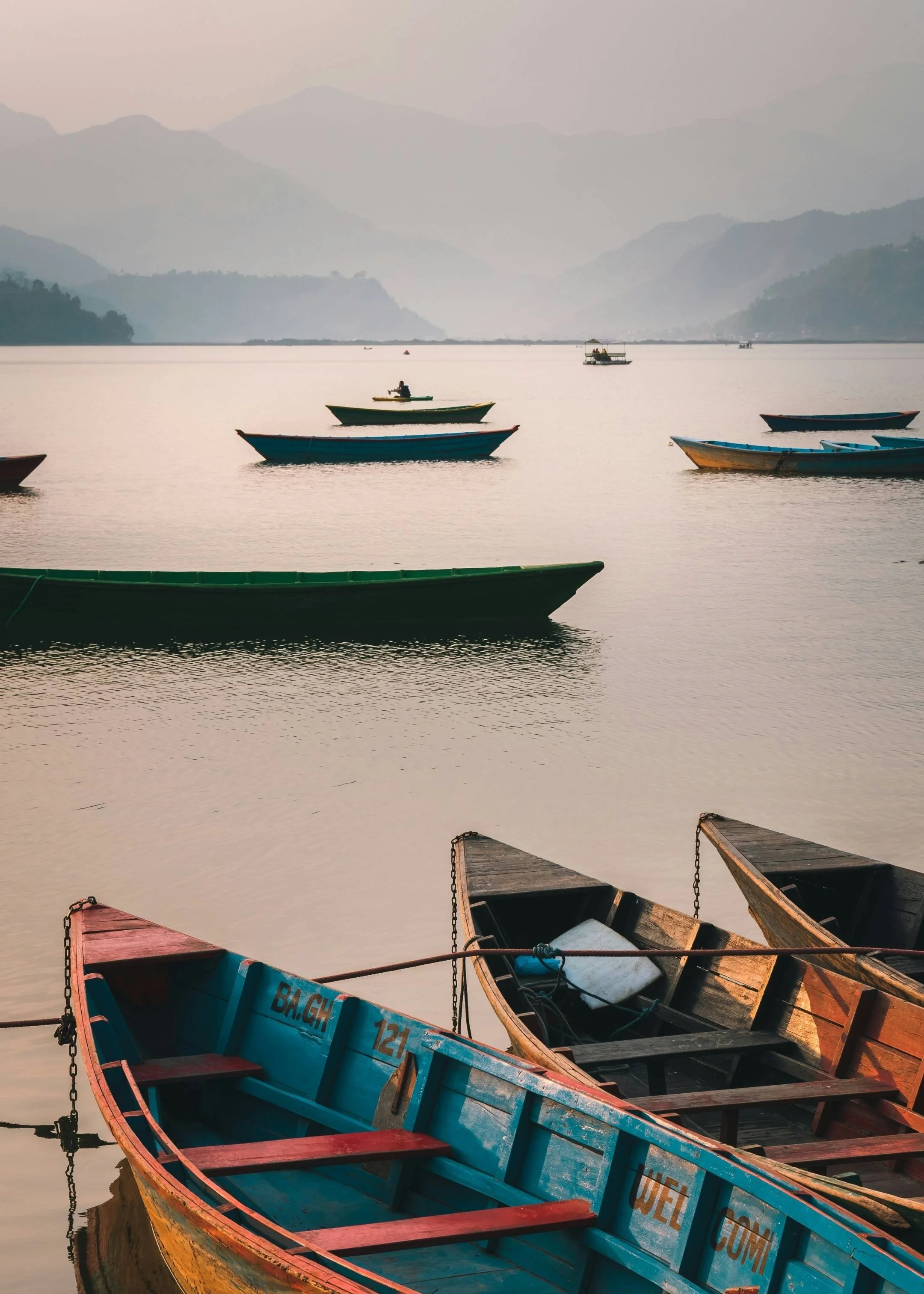 barques sur le lac de pokhara au coucher du soleil lors du retour du trek des annapurnas