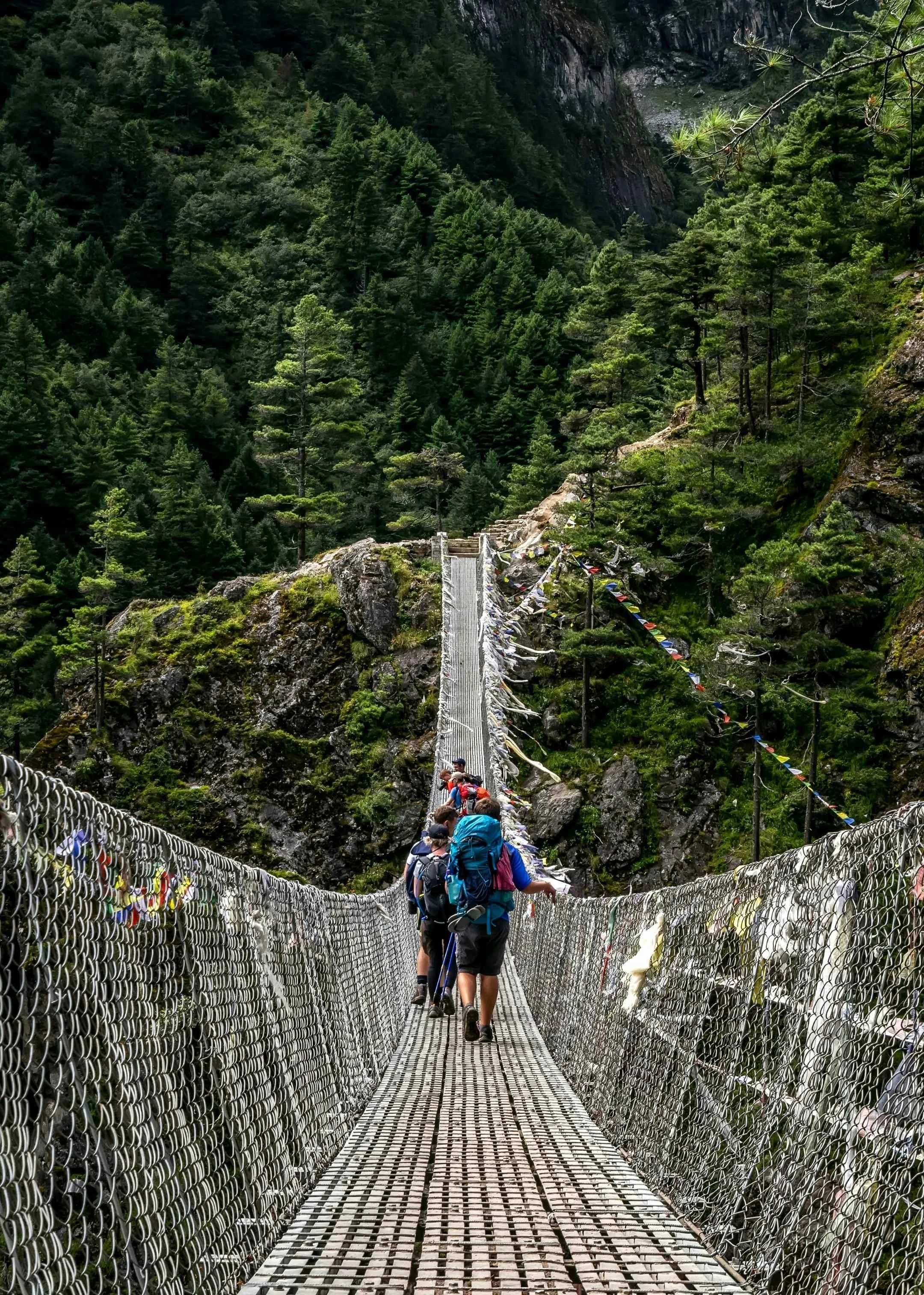 trekkeurs sur un pont suspendu dans la vallée de la kali gandaki durant le trek de la route du sel au Népal