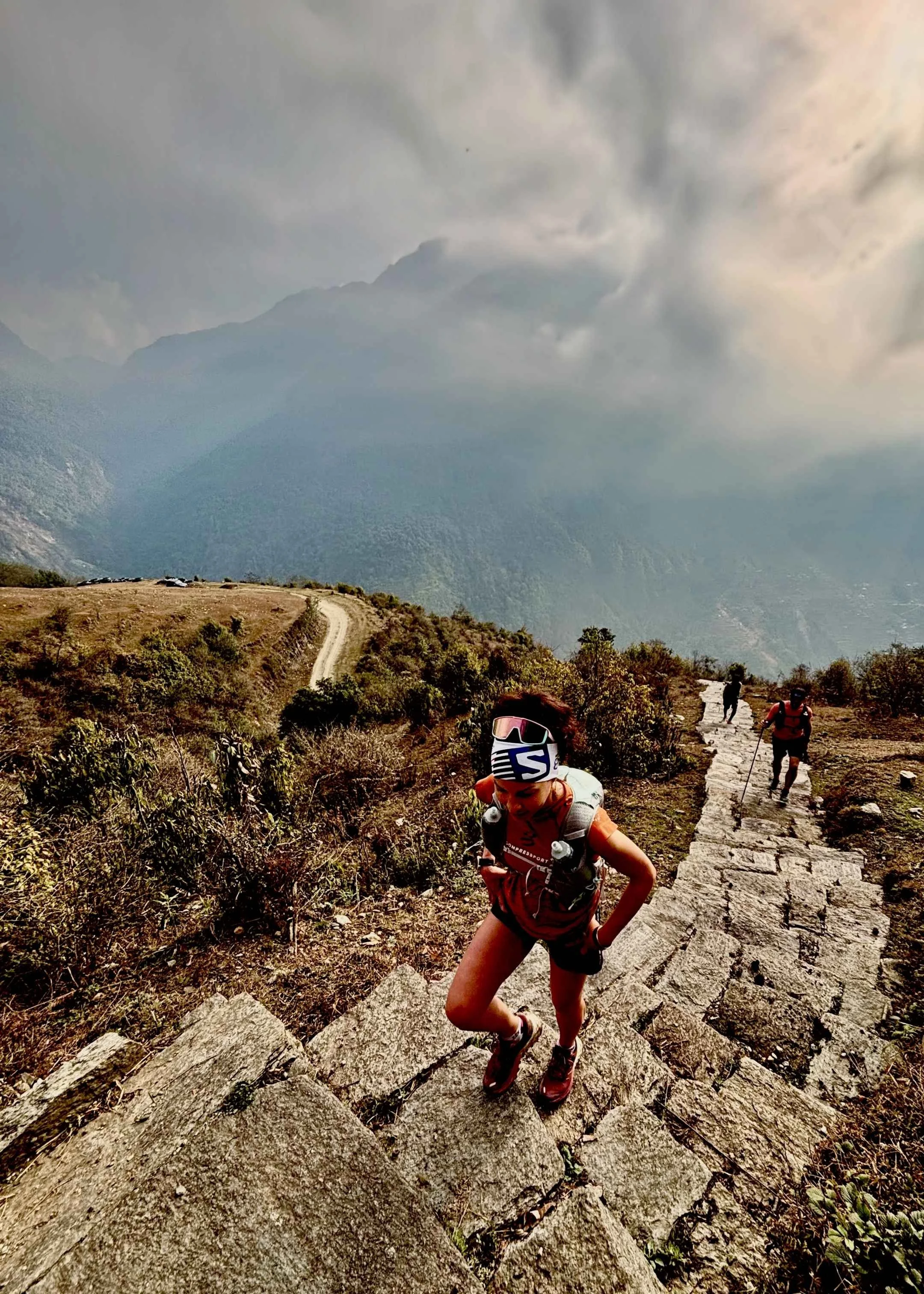 trailruneuse dans les escaliers menant à Gorephani, dans les annapurnas avec vue sur la vallée.