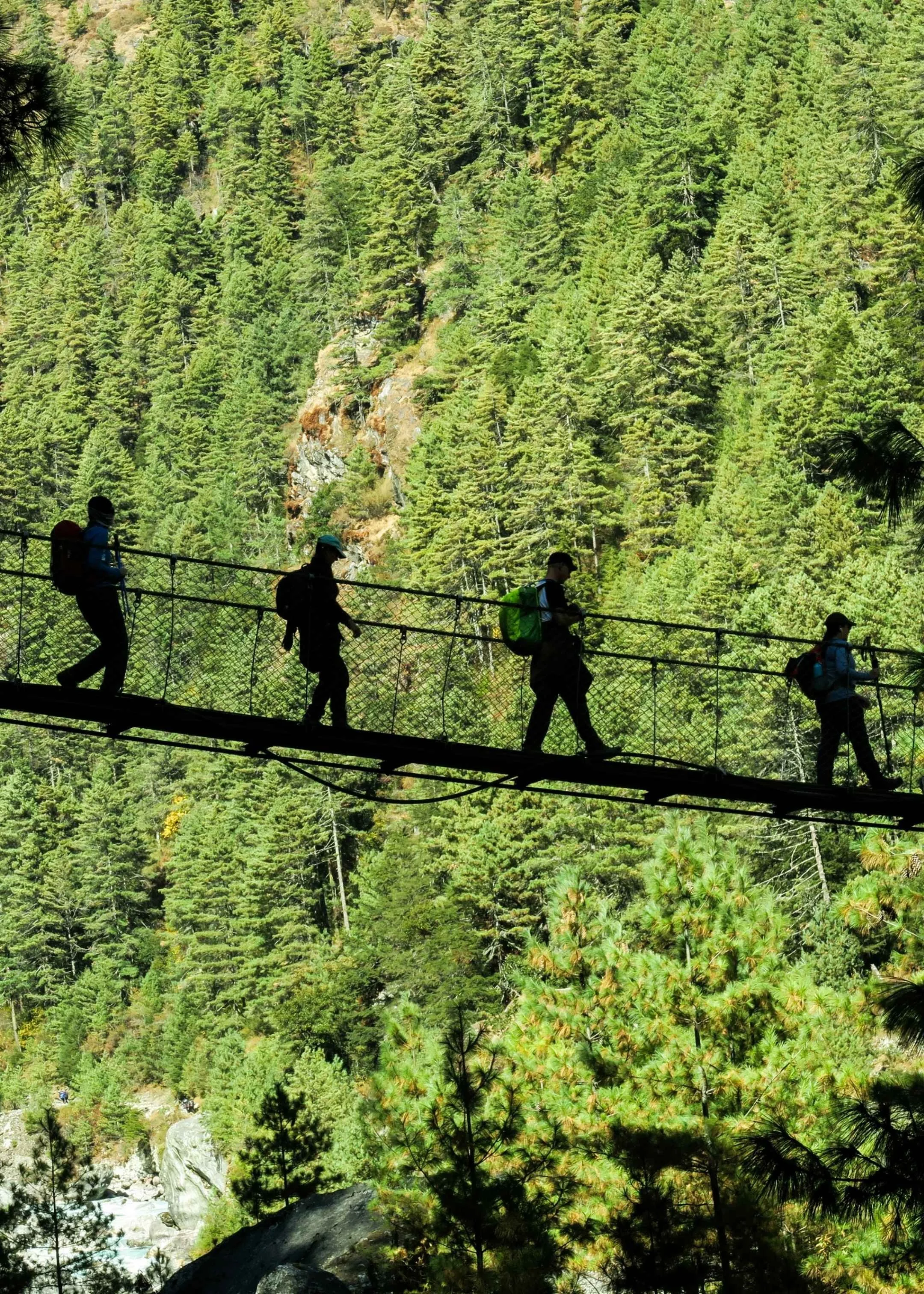 groupe de trekkeur sur un pont suspendu lors des premières journées du tour du manaslu