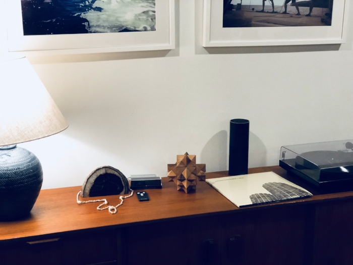 Pictured: Pure Genius Acorn, next to a lamp, geode, and vinyl record player on a living room cabinet.