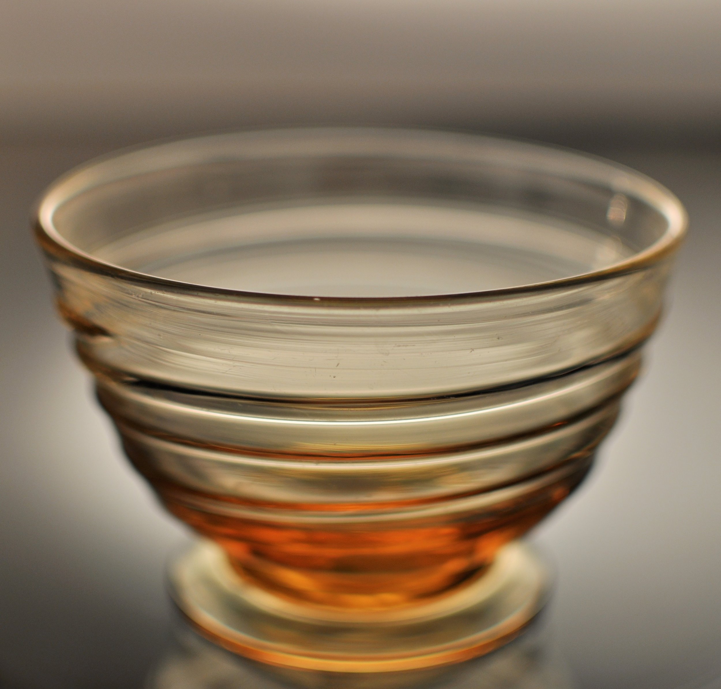 Small ribbon-trailed glass bowl. Gold amber, Whitefriars, designed 1930s