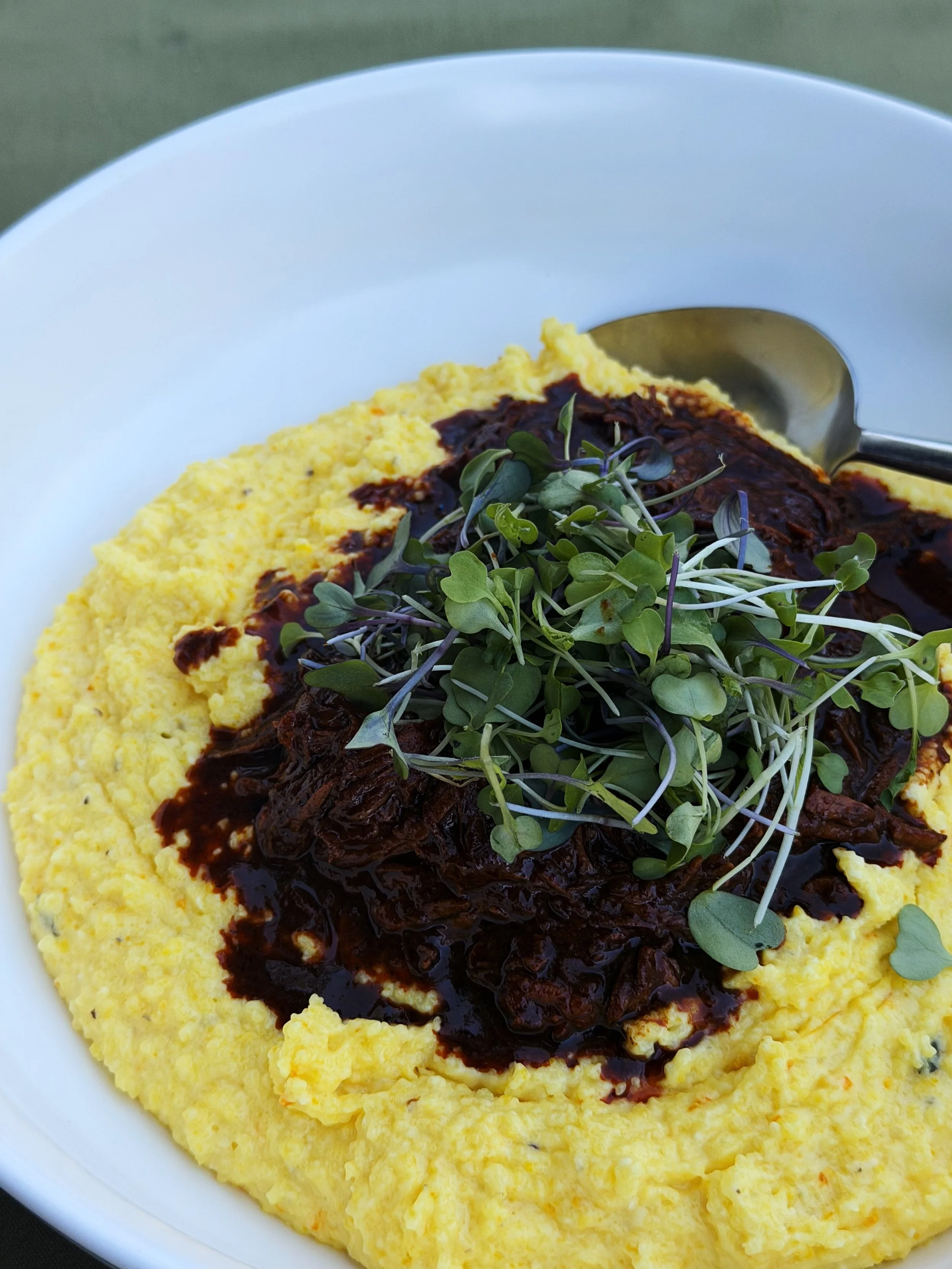 Family style saffron grits and black mole pulled pork 