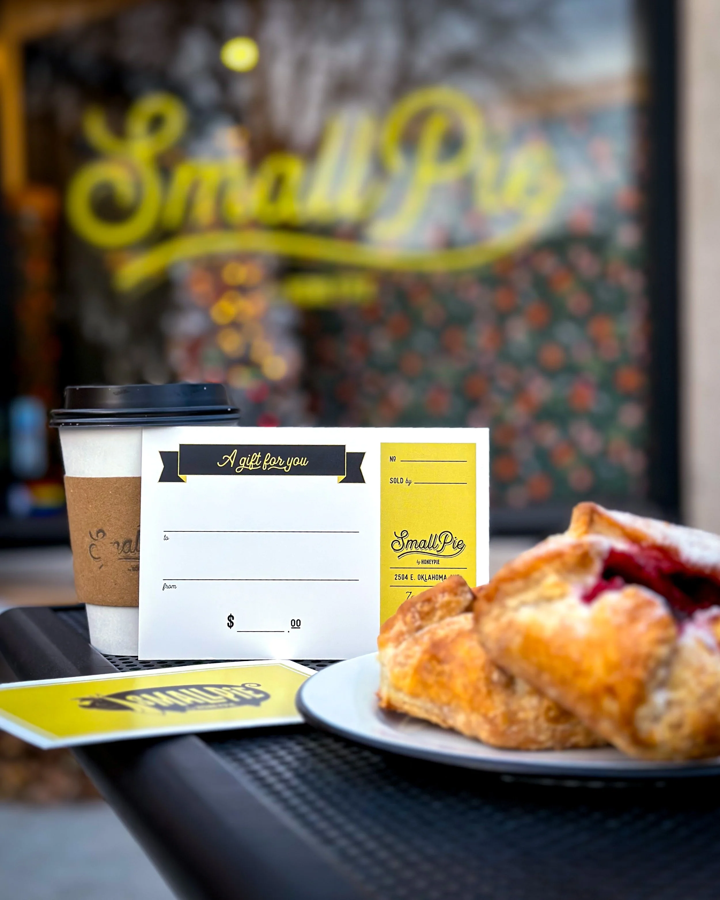 Smallpie gift card surrounded by a Door County cherry handpie and a cup of coffee.