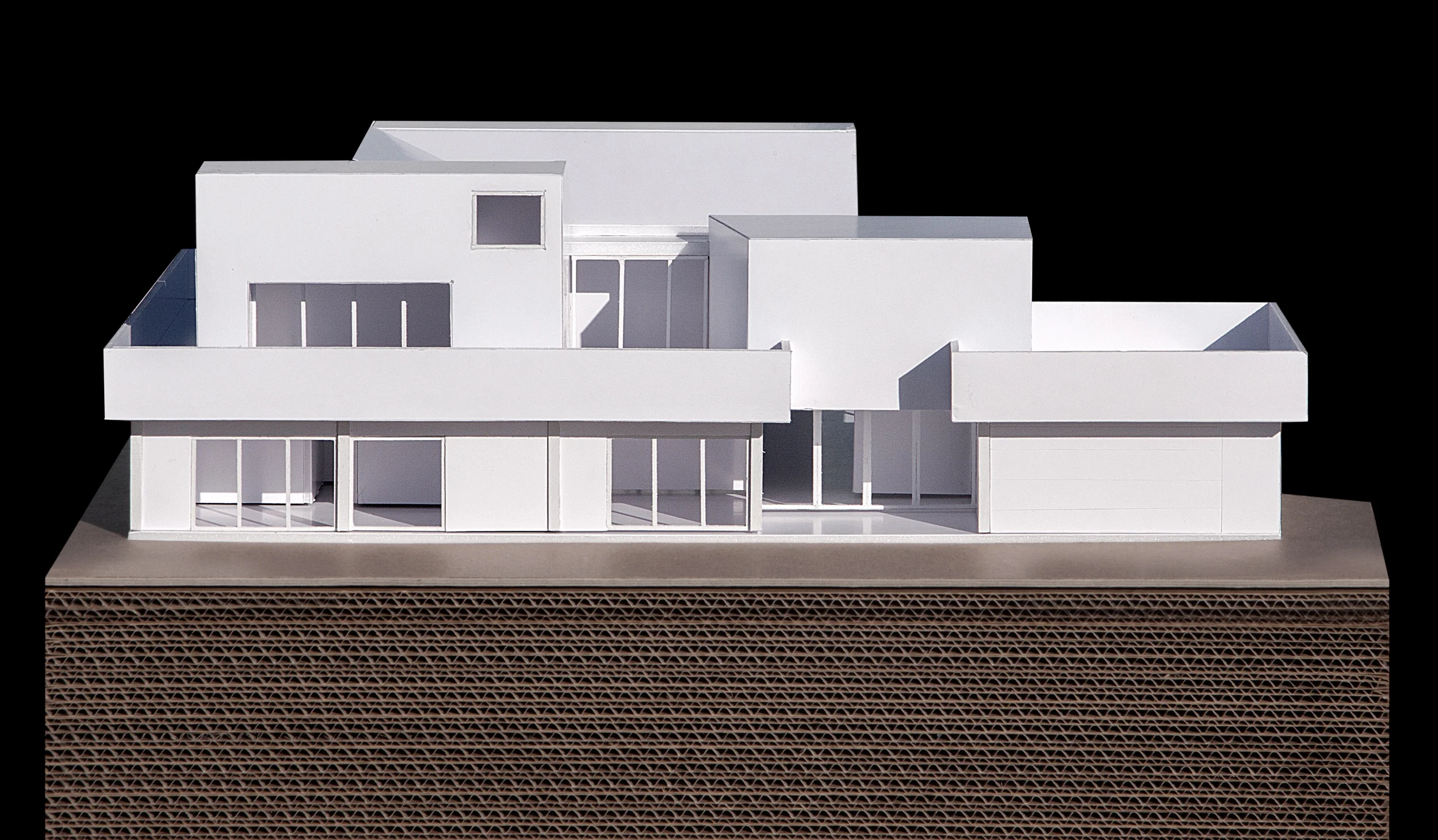 View of the model showing the front facade that faces the street with the recessed entrance and three bedroom volumes above.