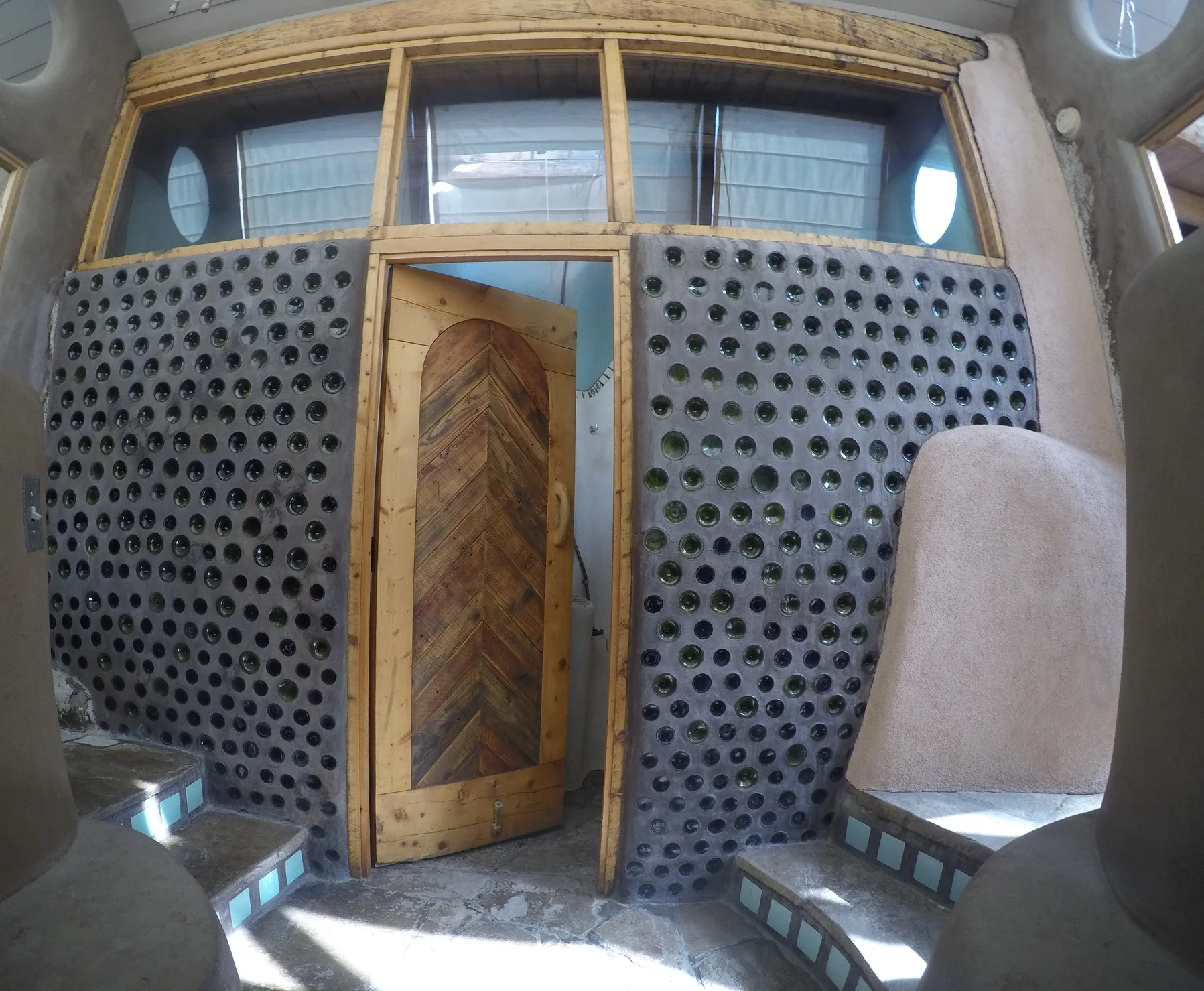 The bathroom behind a bottle wall