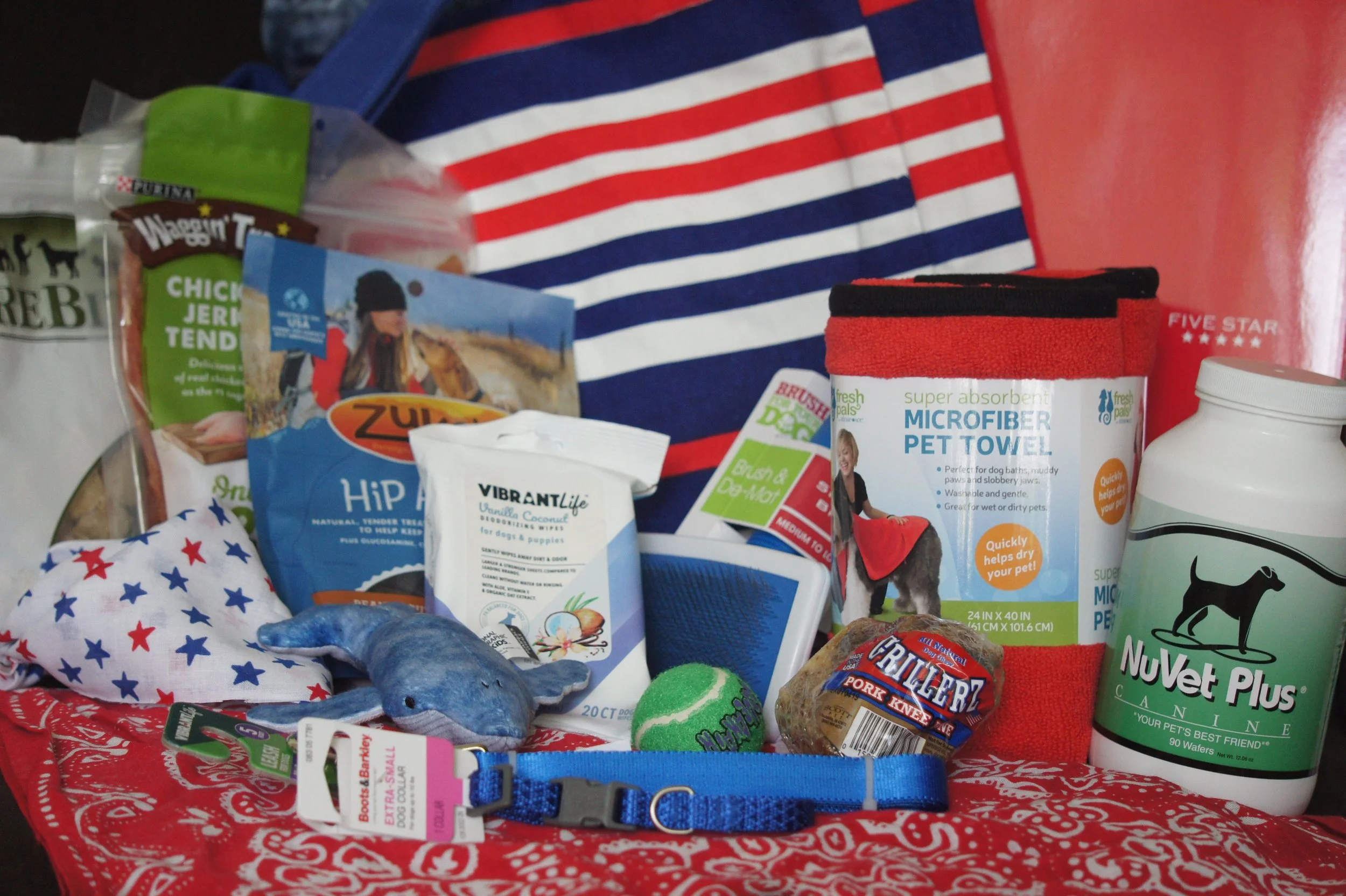 A sample of some of the things that may be included in your puppy starter kit. Samples of NuVet Plus, treat and a small sack of food are also included.