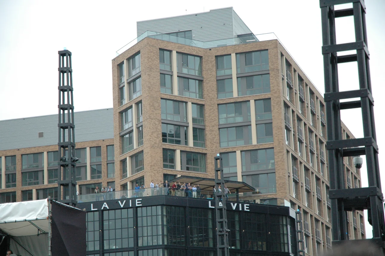 Bystanders on the balcony of a neighboring building