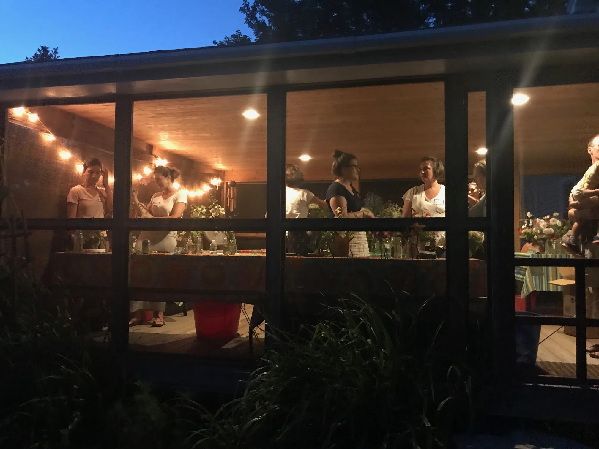 the porch hosting workshop guets on a summer evening