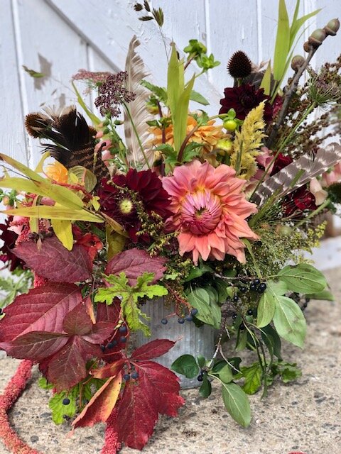 fall tone vase arrangement with dahlias and feathers