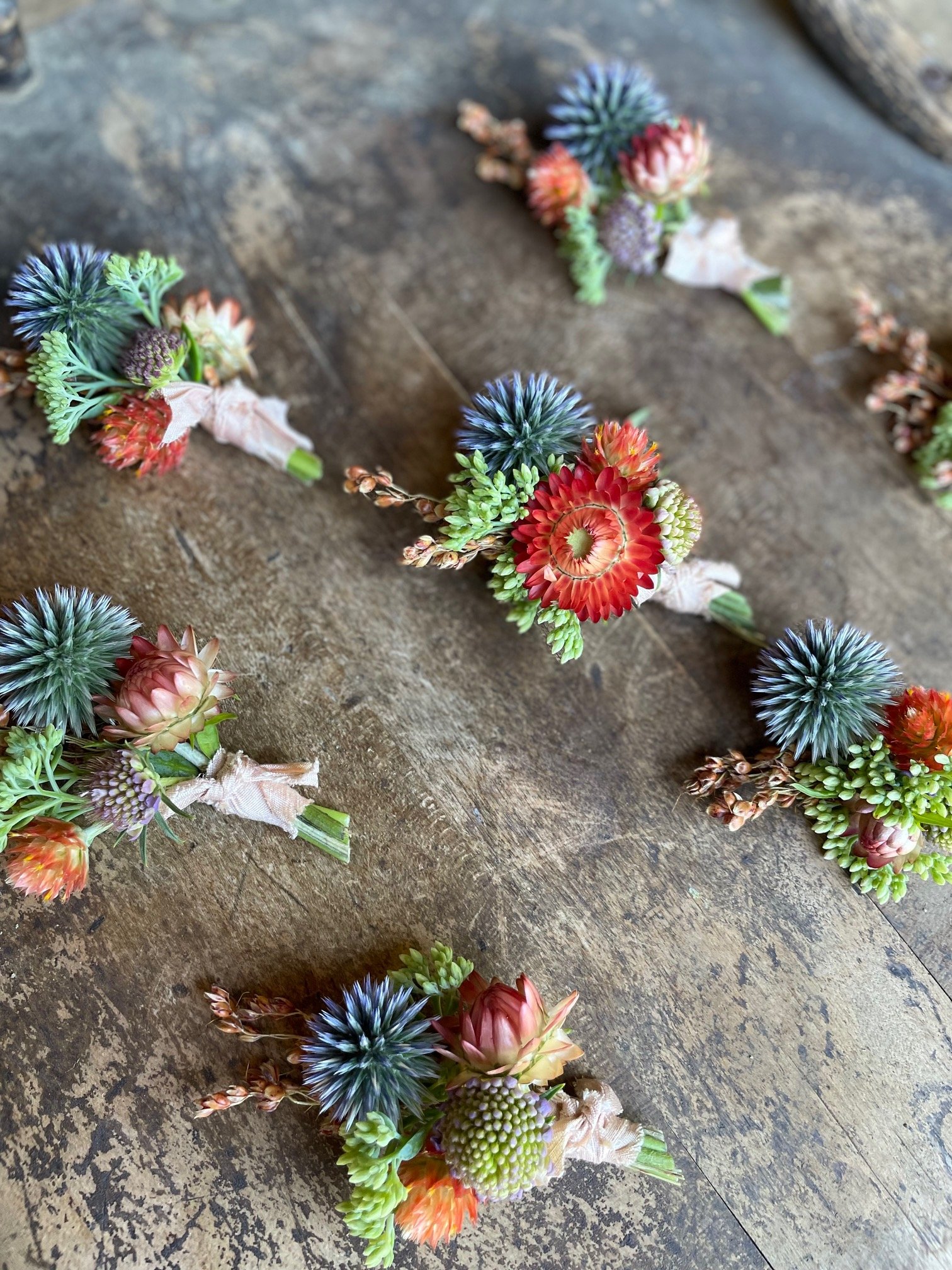 boutonnieres featuring echinops and strawflower