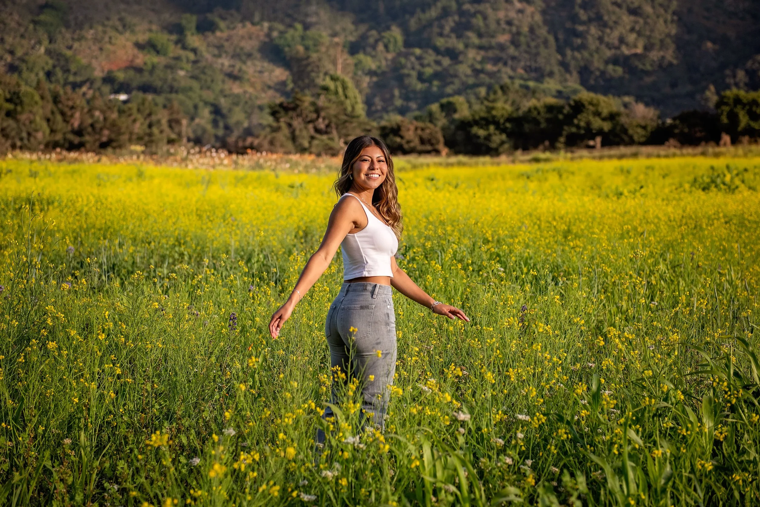 Aubrey smiling in a wildflower field at Garland Ranch during her Salinas High senior portrait session