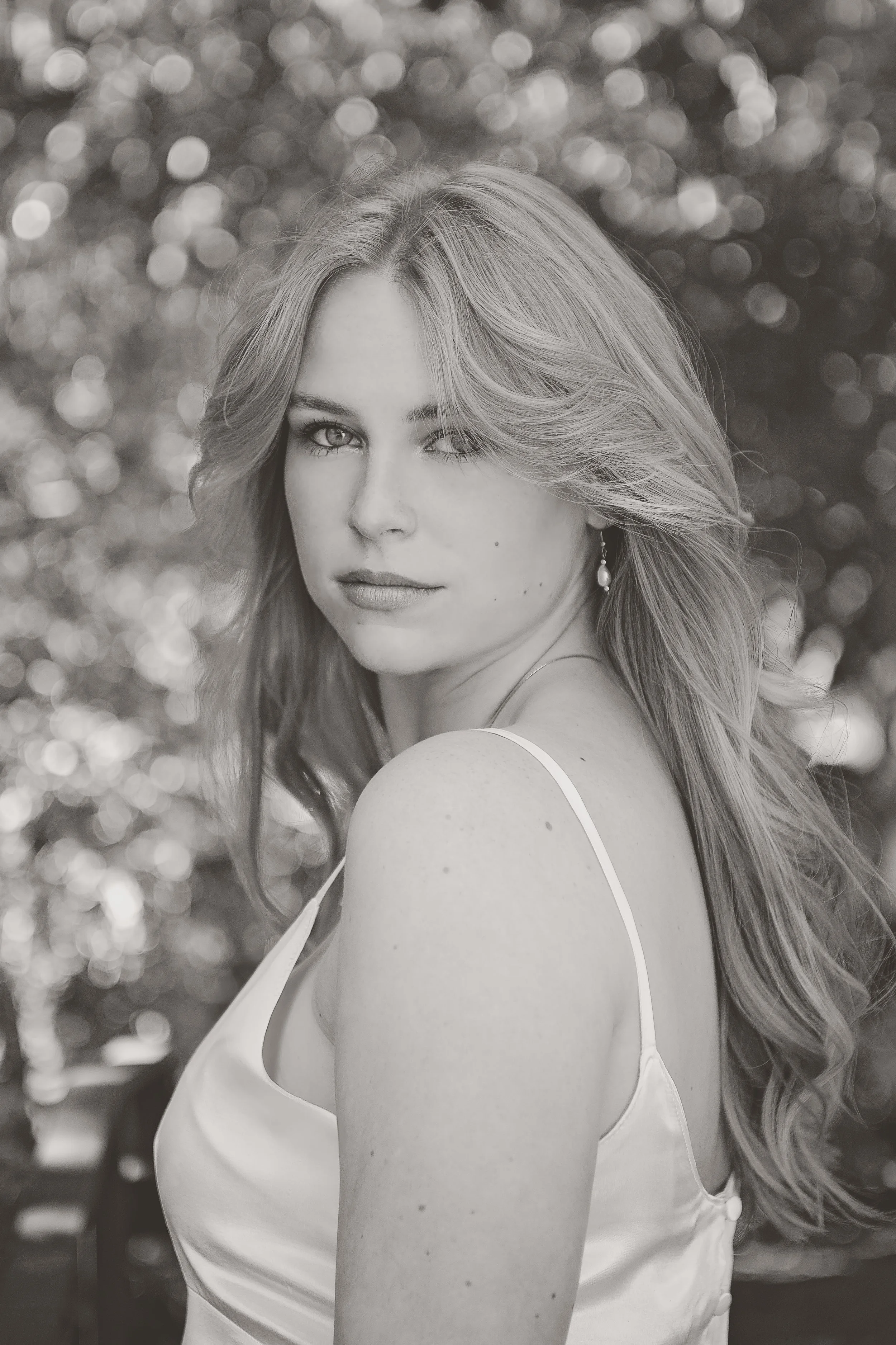 Black-and-white senior portrait of Camden wearing her mother’s vintage white dress in Carmel