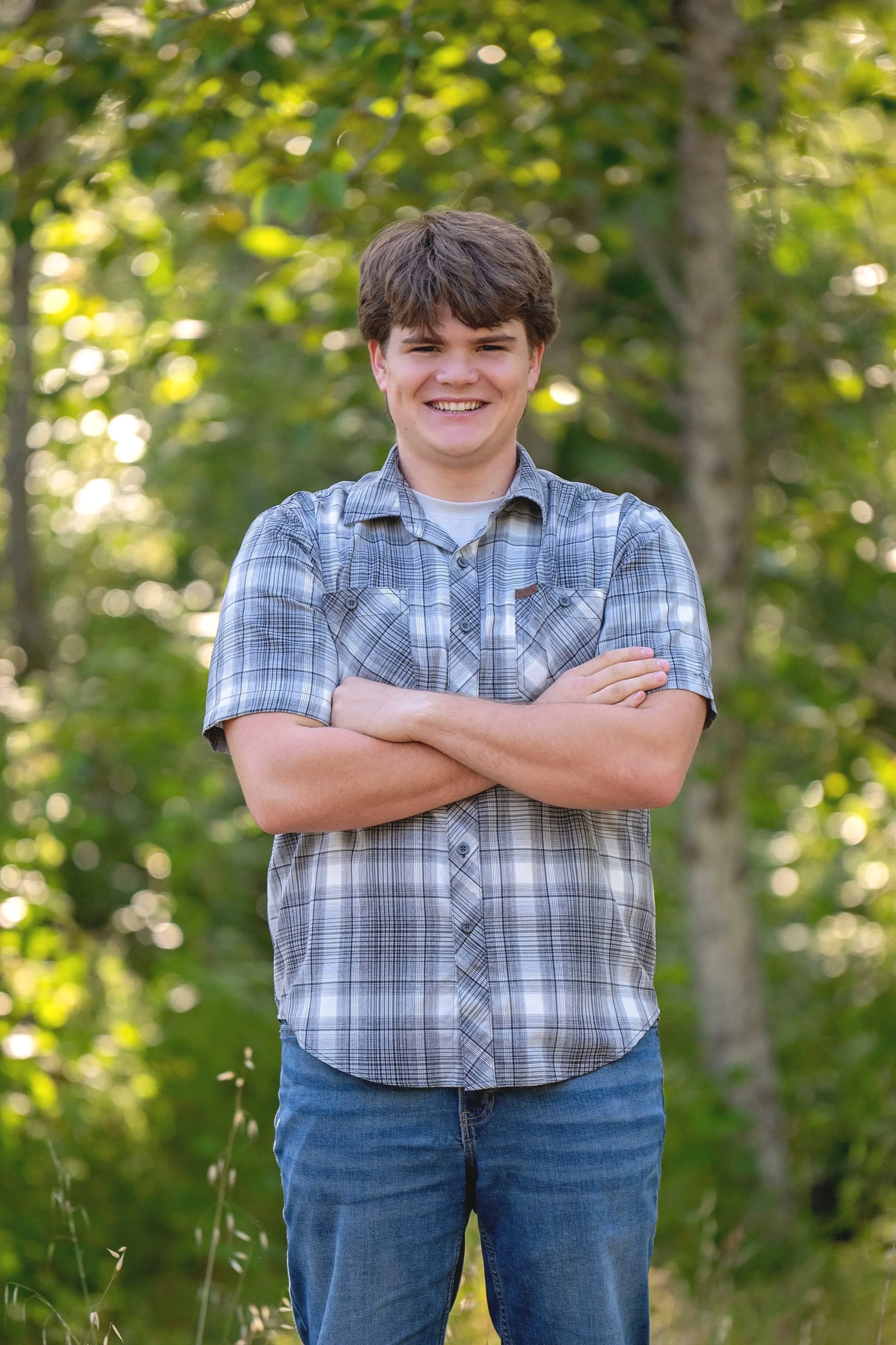 Relaxed outdoor senior portrait of Gianni in a plaid shirt among the trees at Garland Ranch.