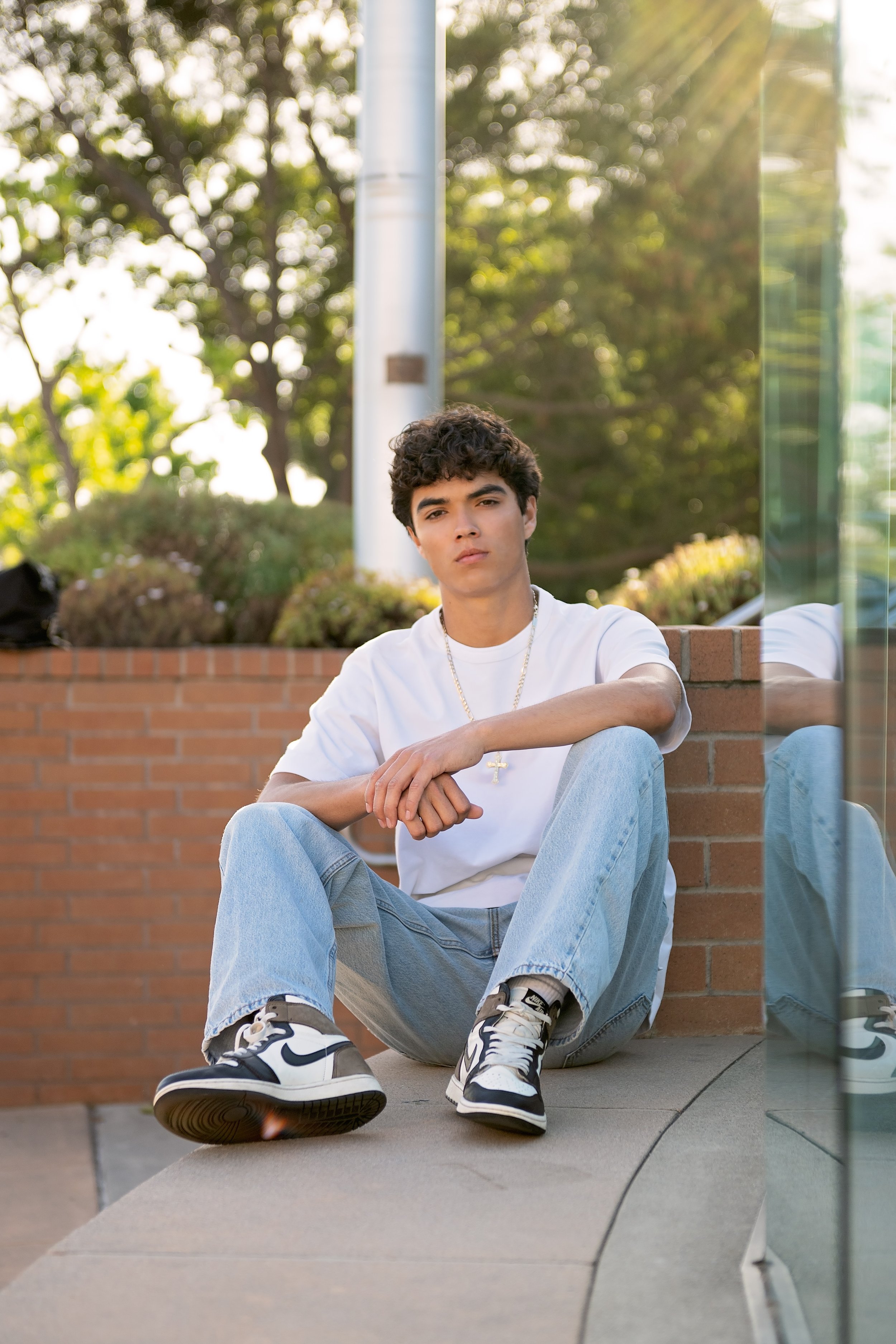 Salinas High School senior Cruz sitting near the National Steinbeck Center during his Downtown Salinas portrait session.