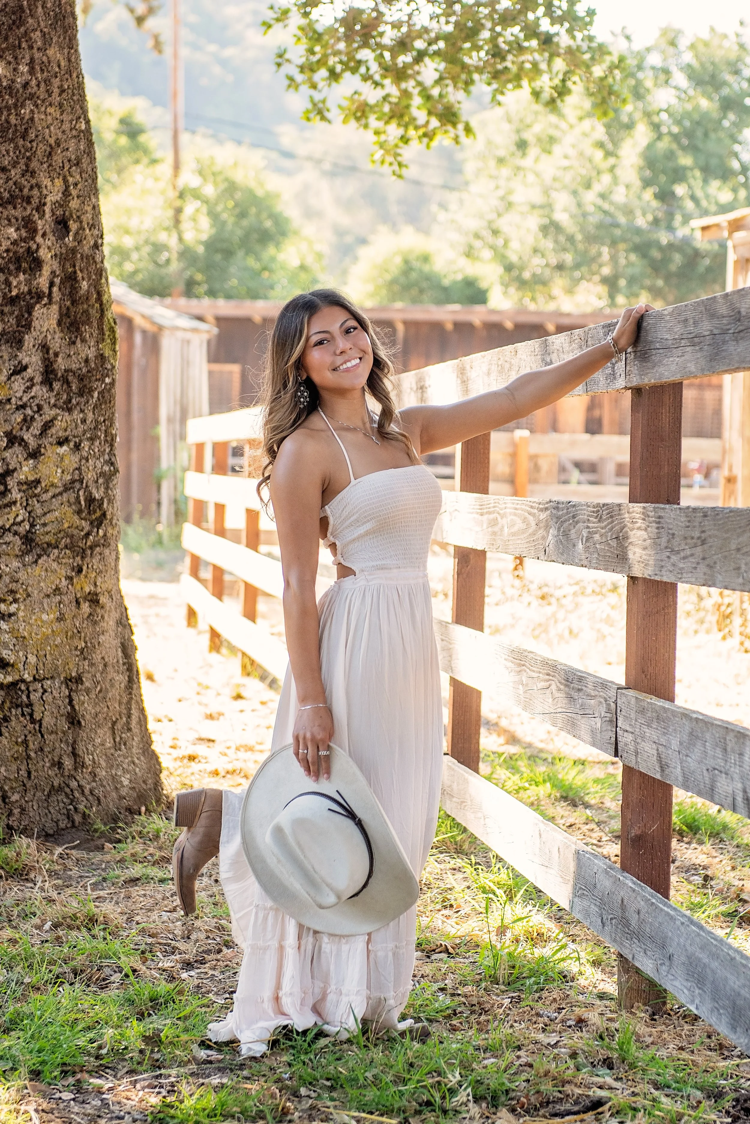 Aubrey’s Salinas High senior portrait in a white dress beside a rustic fence at Garland Ranch in Carmel Valley