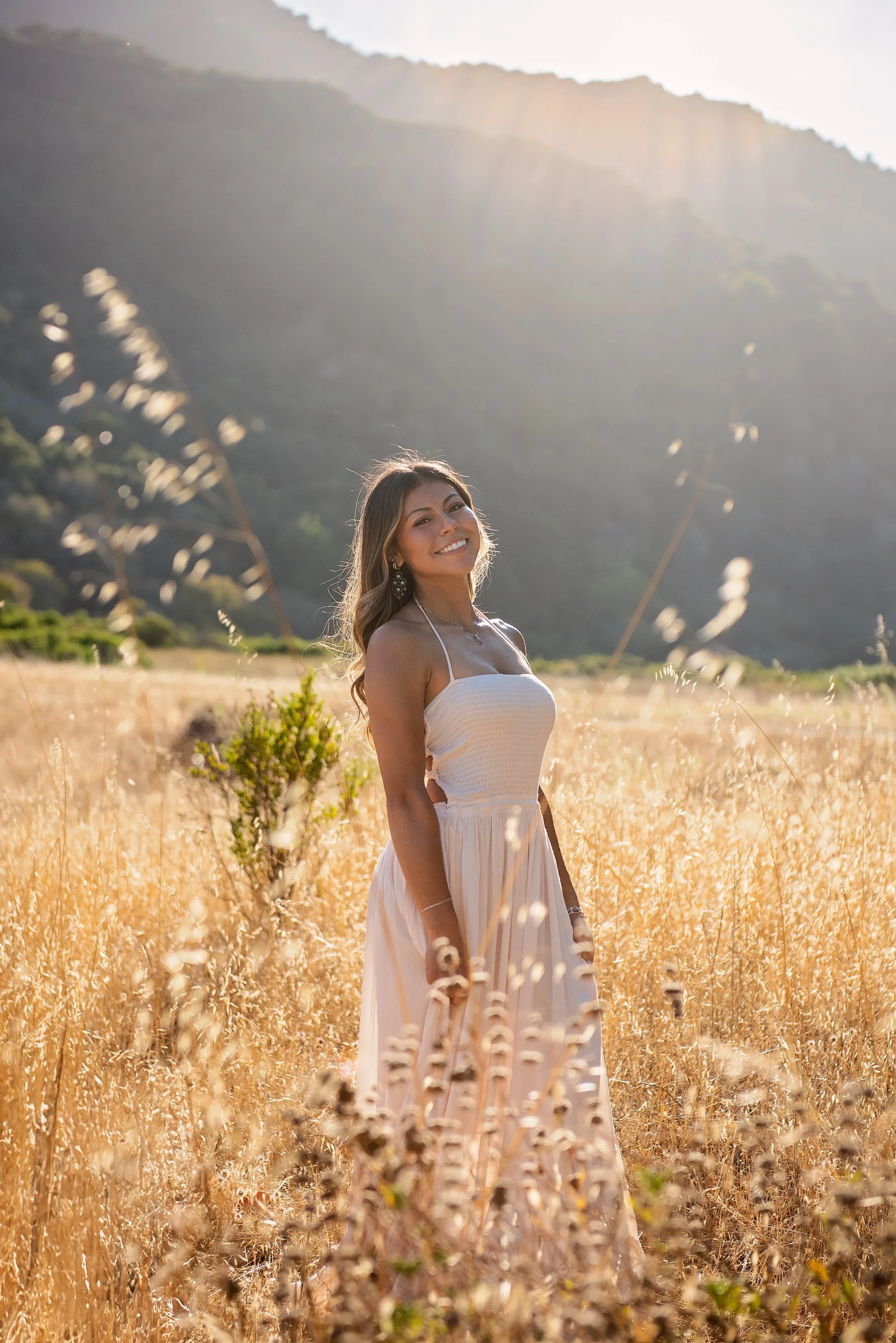 Aubrey smiling in a wildflower field at Garland Ranch during her Salinas High senior portrait session