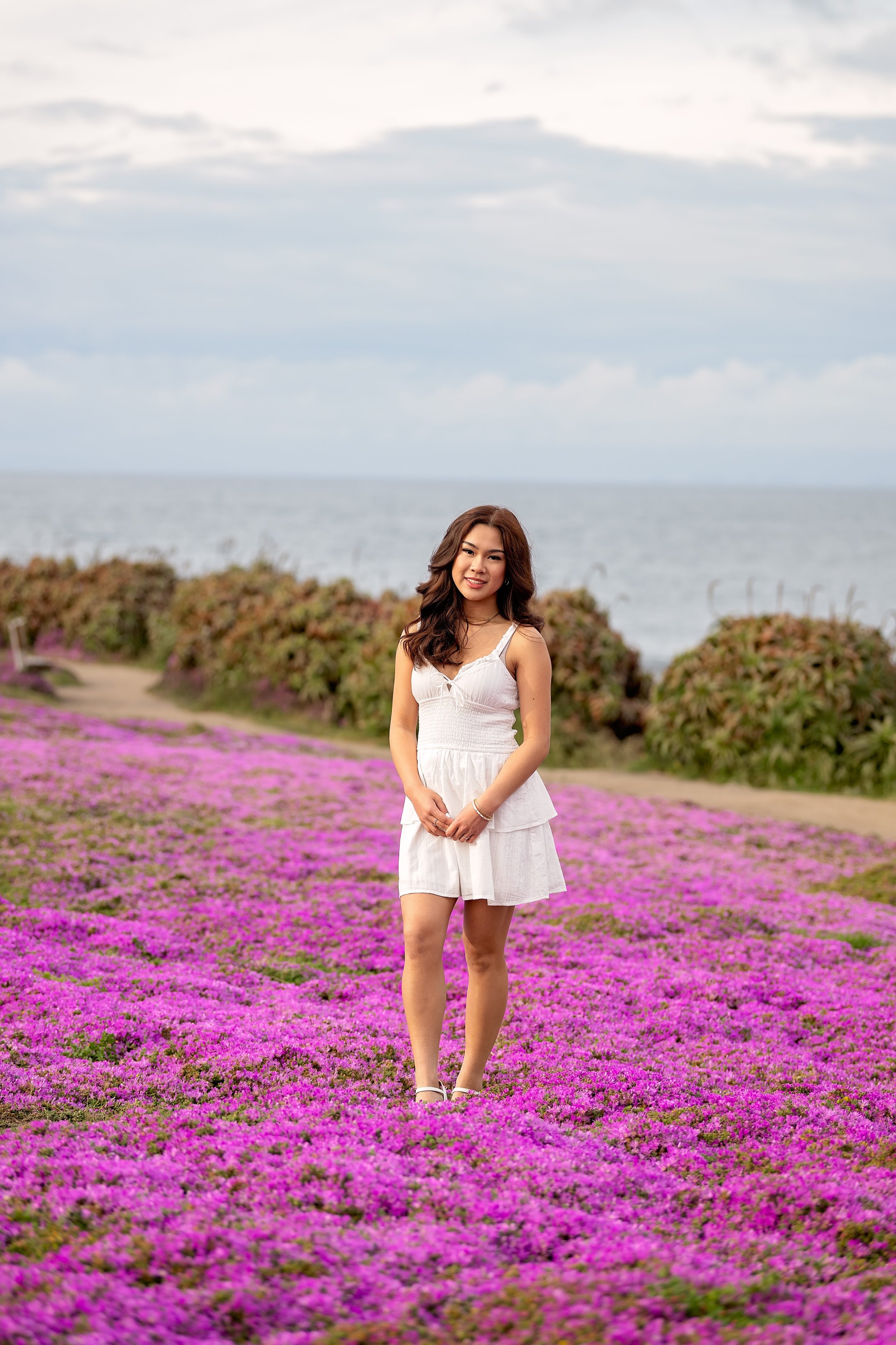 Senior girl in white dress overlooking the Pacific Ocean