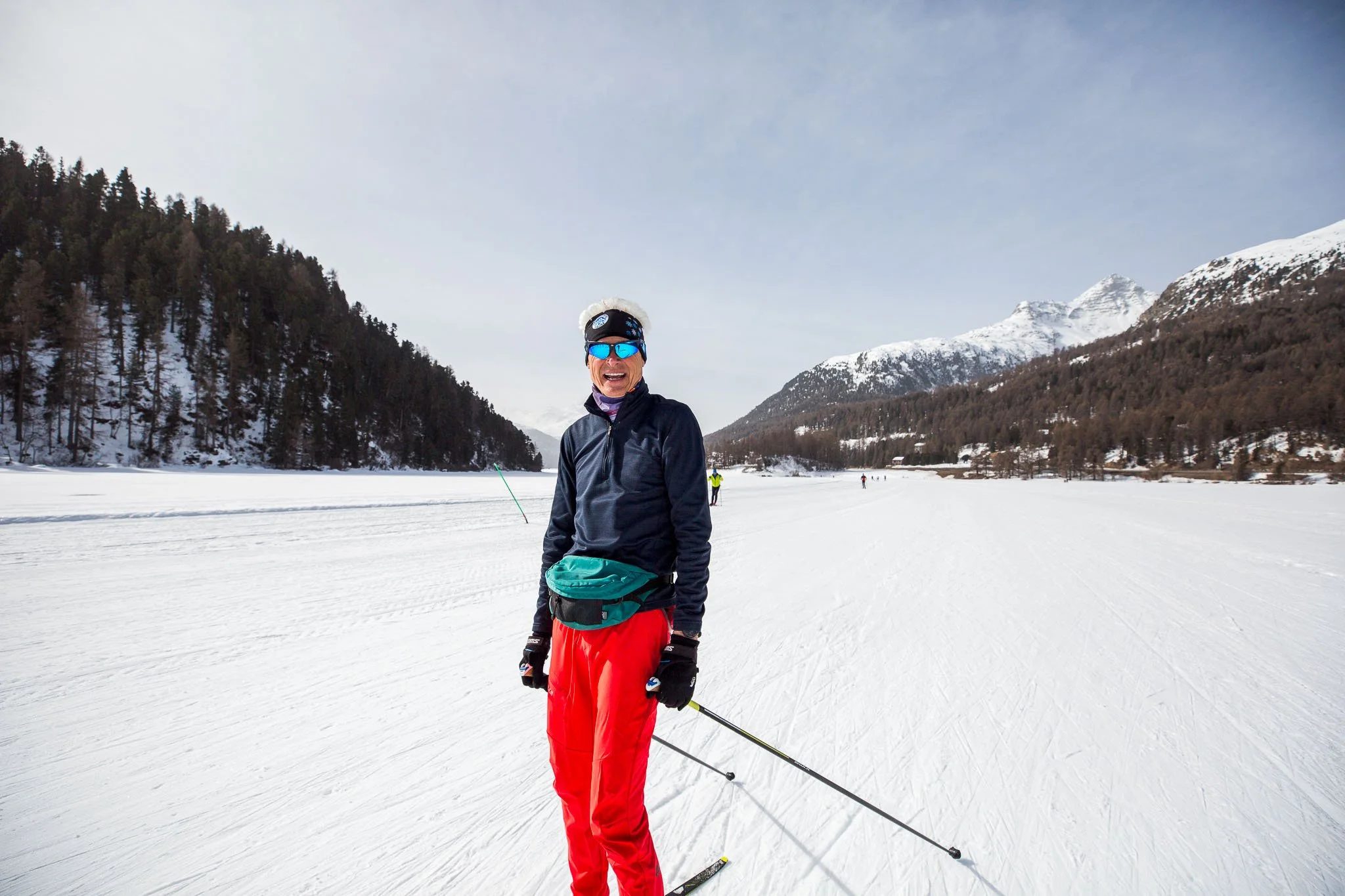 Skiing through the breathtaking Engadin Valley in Switzerland, pausing to take in panoramic views of the alpine peaks and valley floor.