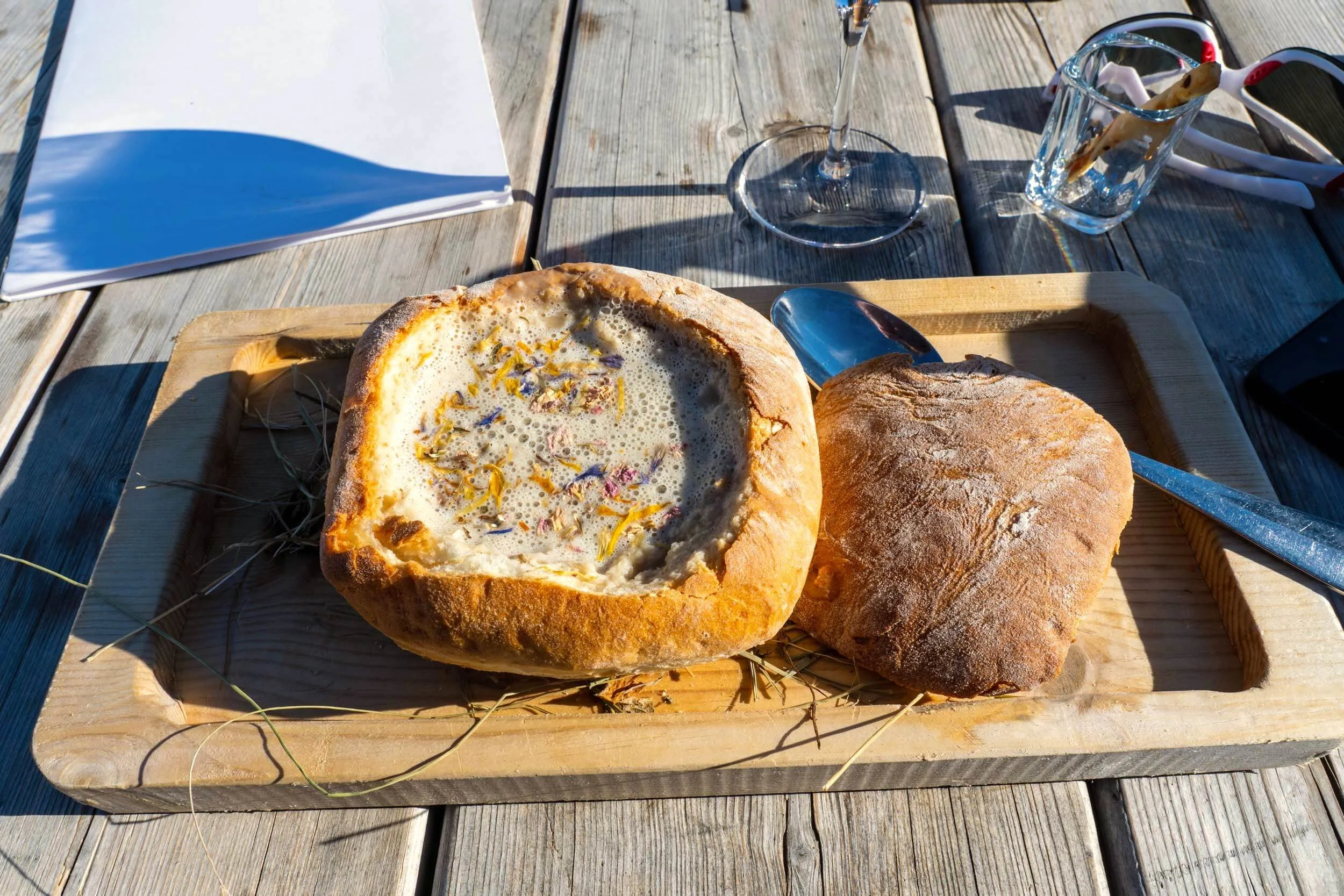 A warm bowl of traditional hay soup garnished with fresh local herbs from the Seiser Alm plateau