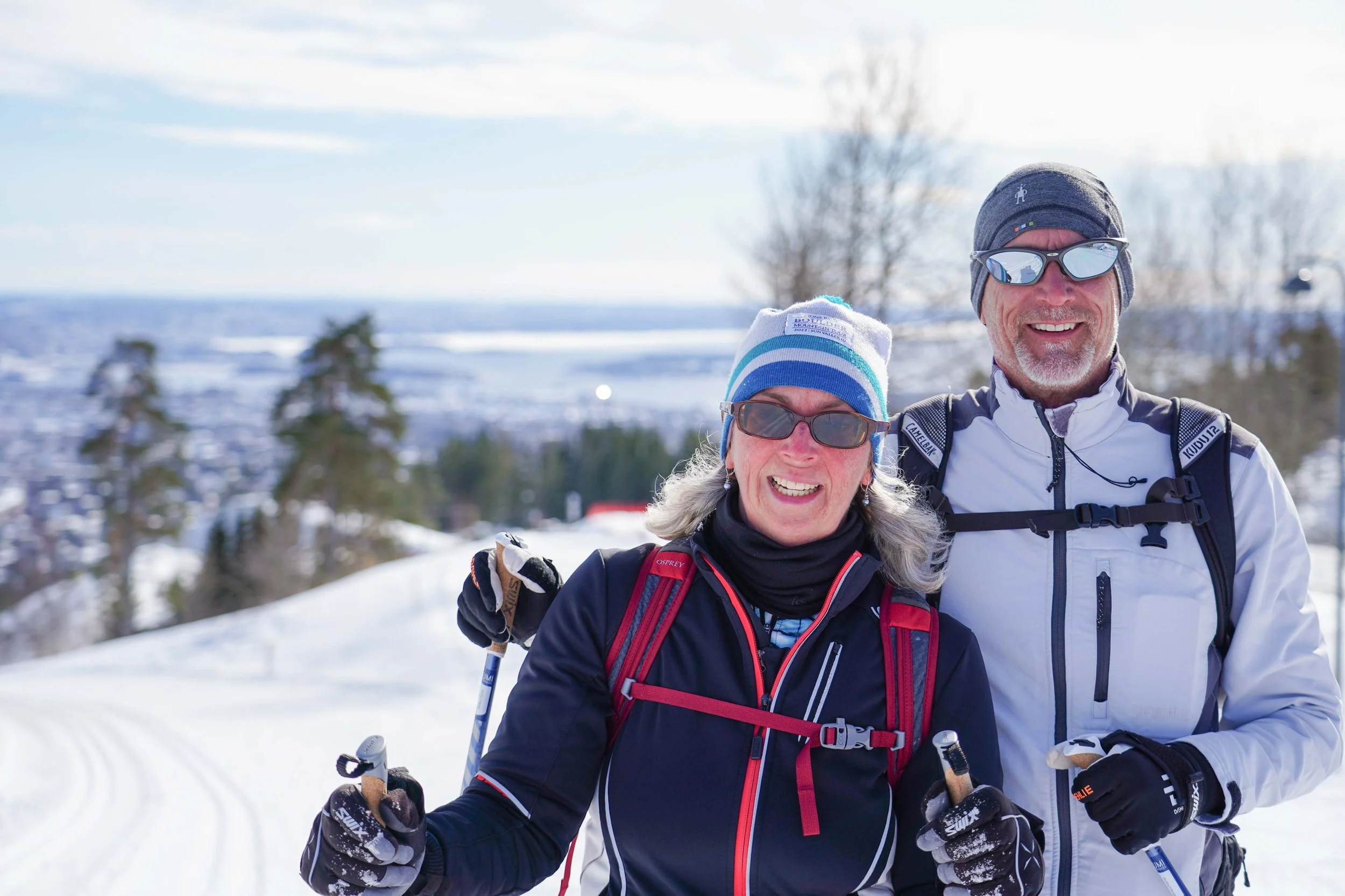Happy couple cross-country skiing on scenic Norwegian trails with Lumi Experiences