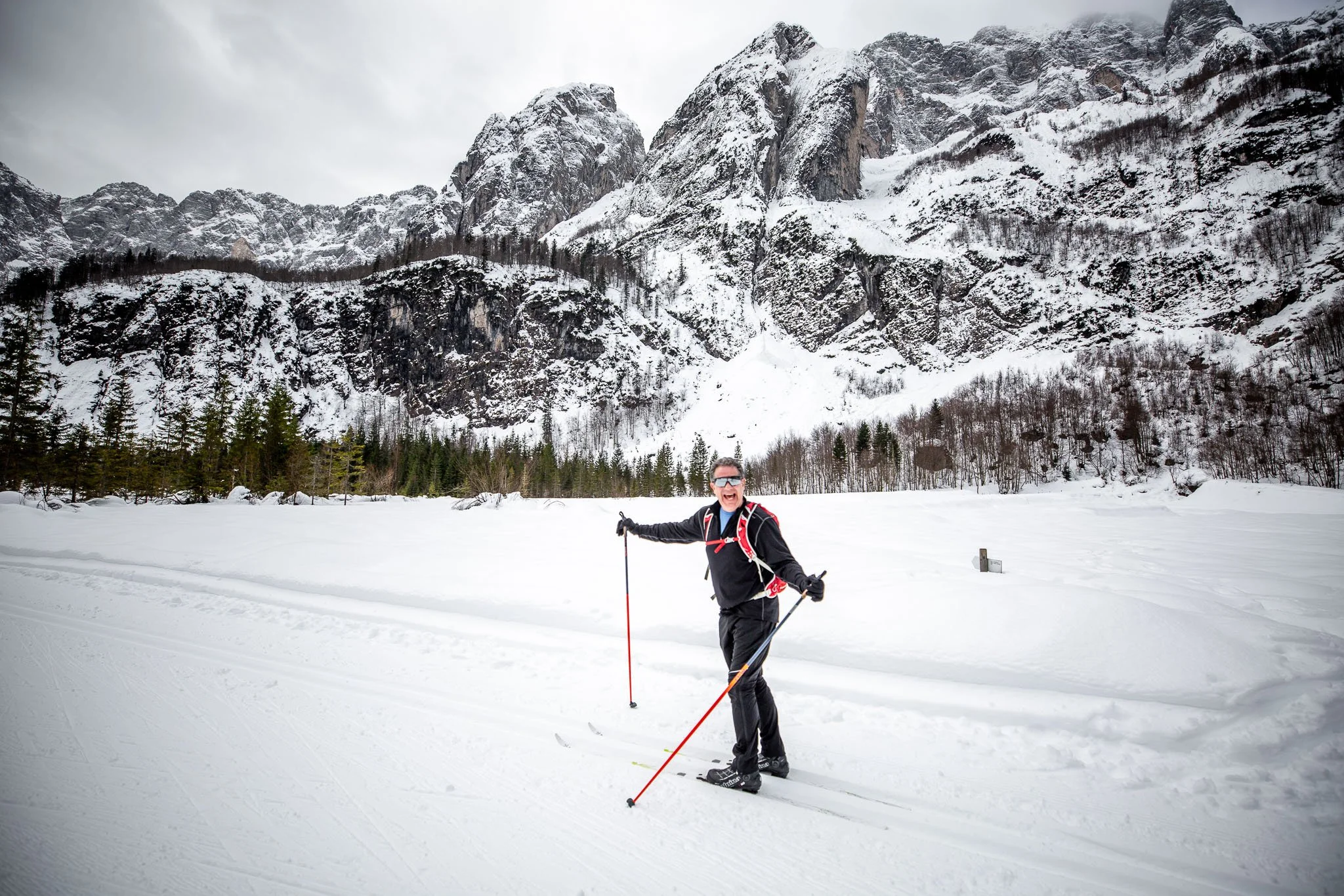 Lumi's Guest Communications Manager Nathan skiing under mountain spires in Slovenia