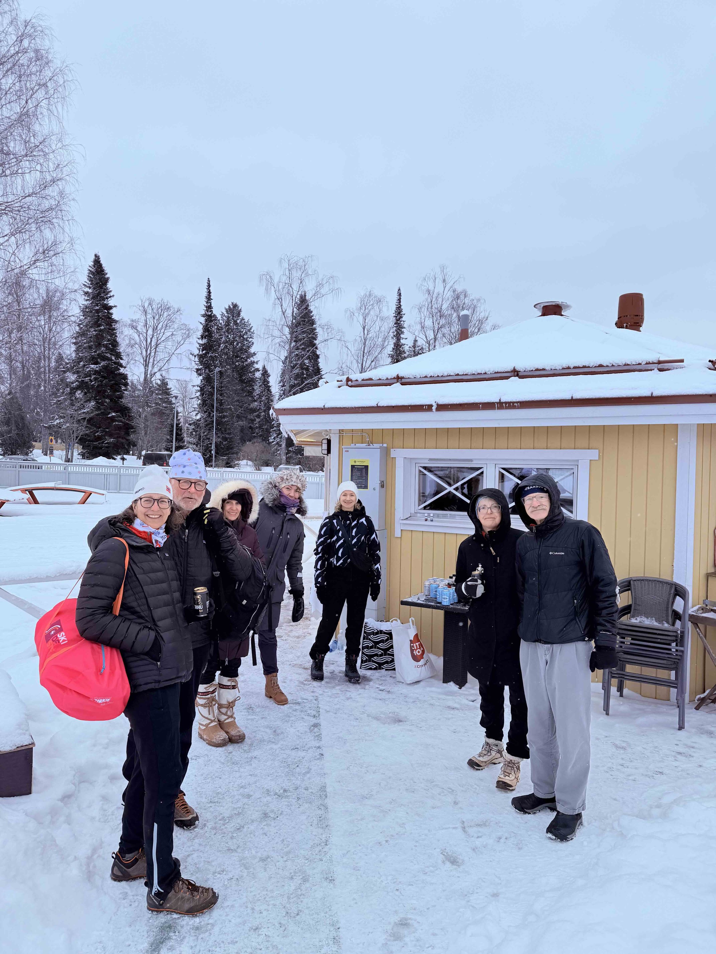 Lumi Experiences travelers gather outside a traditional Finnish sauna, ready to warm up after a day in the snow in Finland.