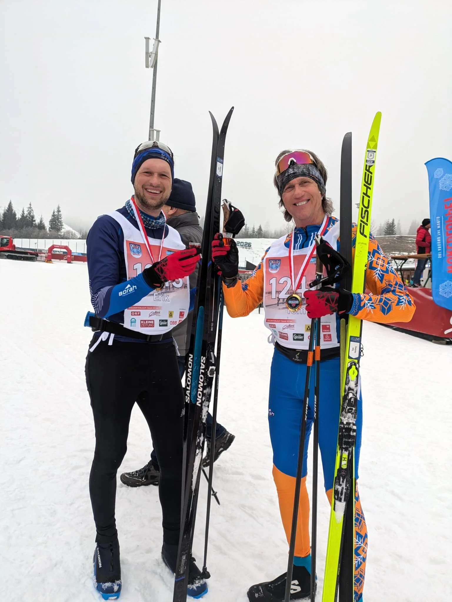 Two smiling finishers celebrating at the finish line of the Dolomitenlauf