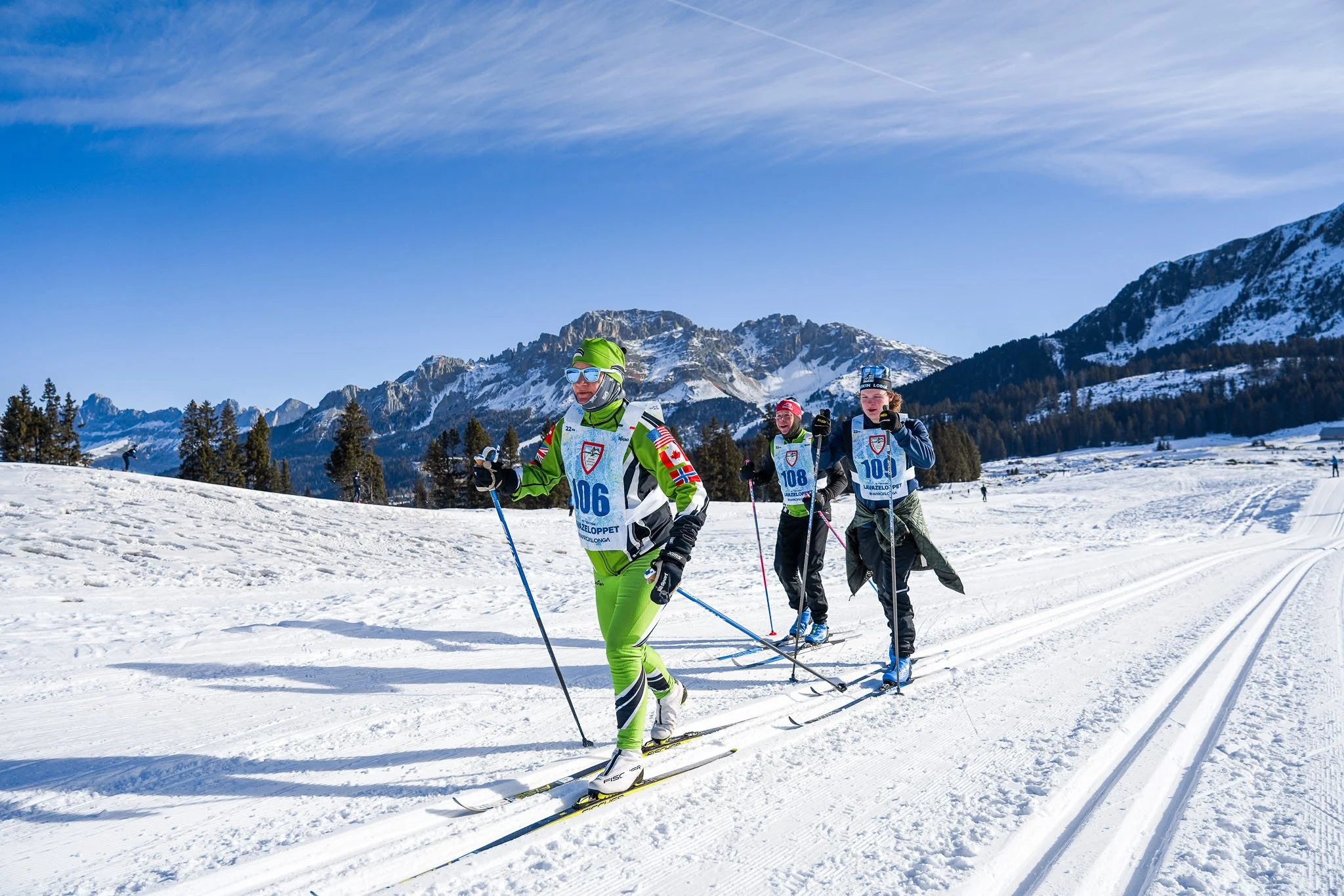 Family cross-country skiing during the Lavazè Loppet with breathtaking alpine scenery