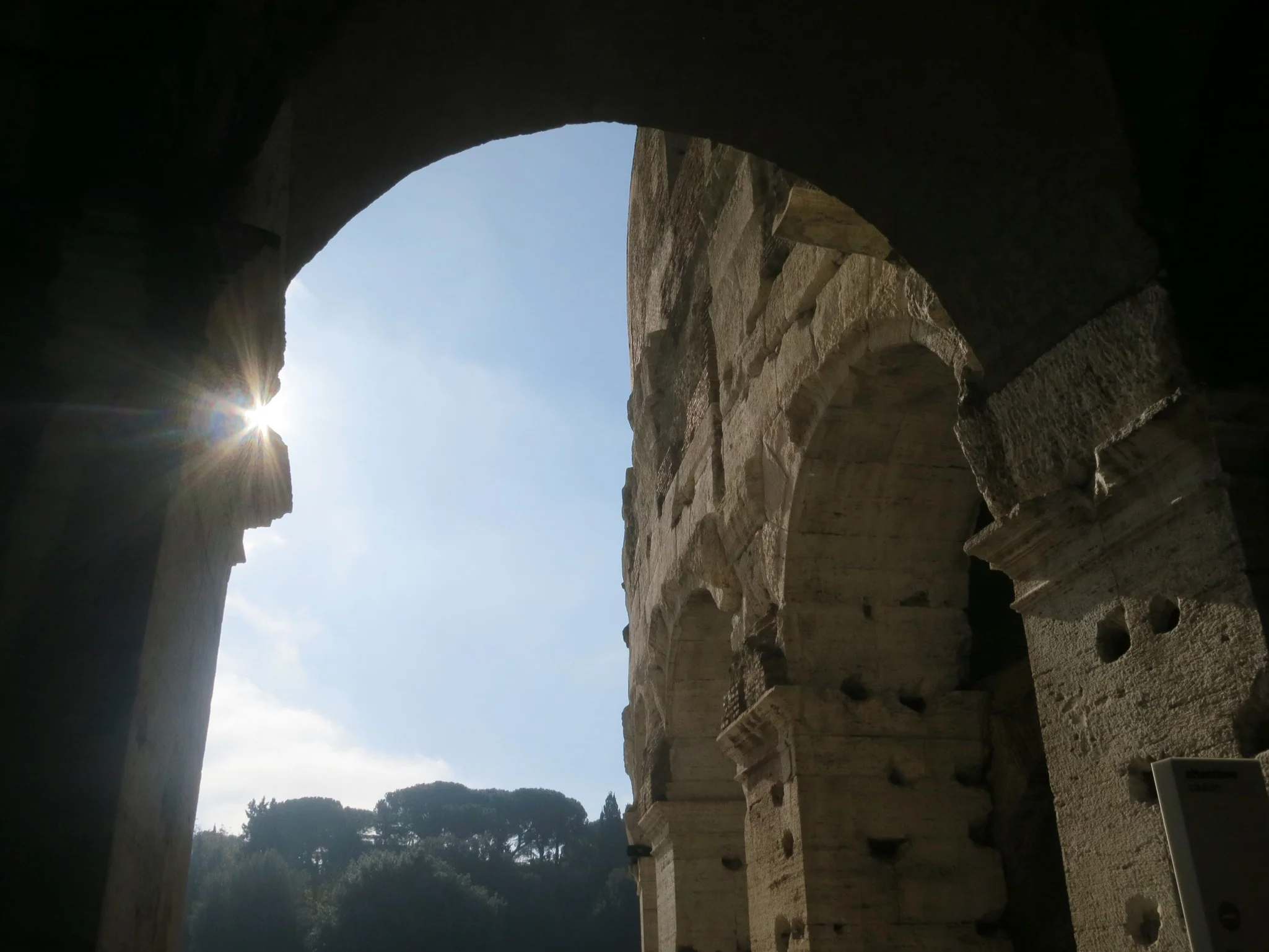 Arches frame beautiful views of the city throughout the Colosseum in Rome, Italy.