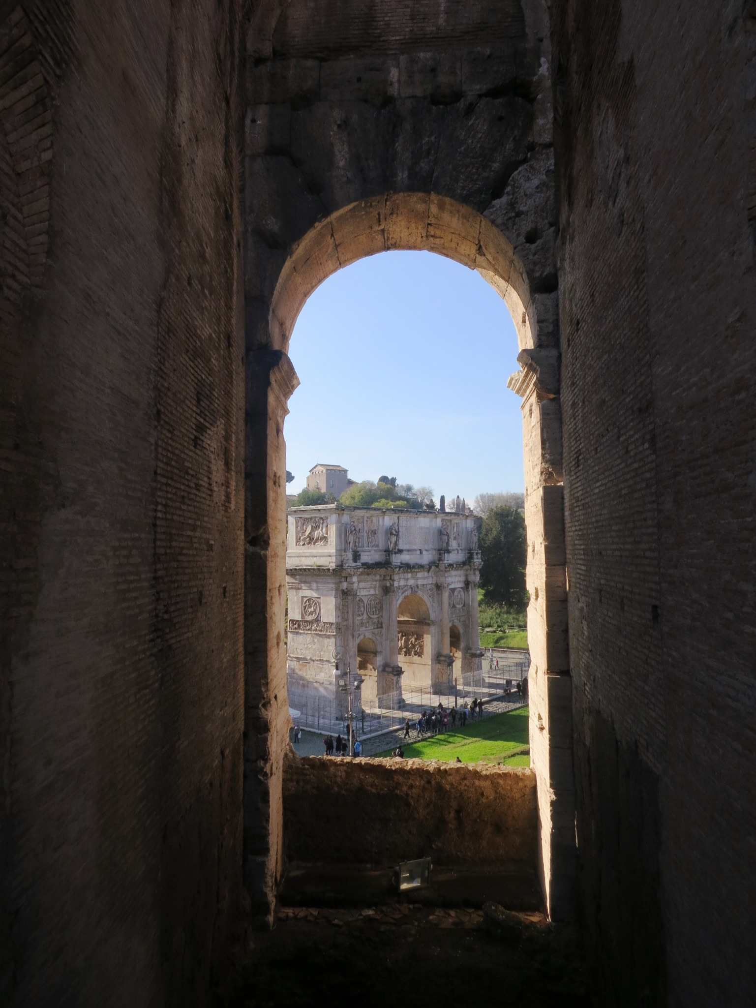 An arch in the Colosseum frames the Arch of Constantine in Rome, Italy.