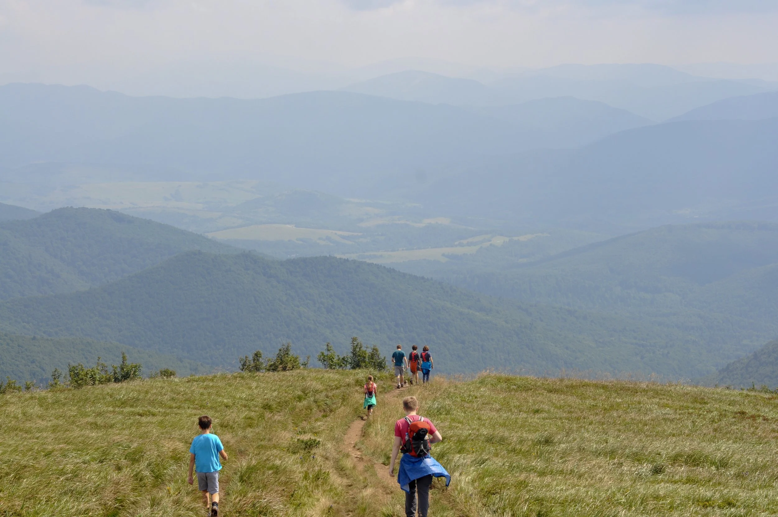 Hikers walking through the połoniny on the Tri-Border hike in the Bieszcady Mountains
