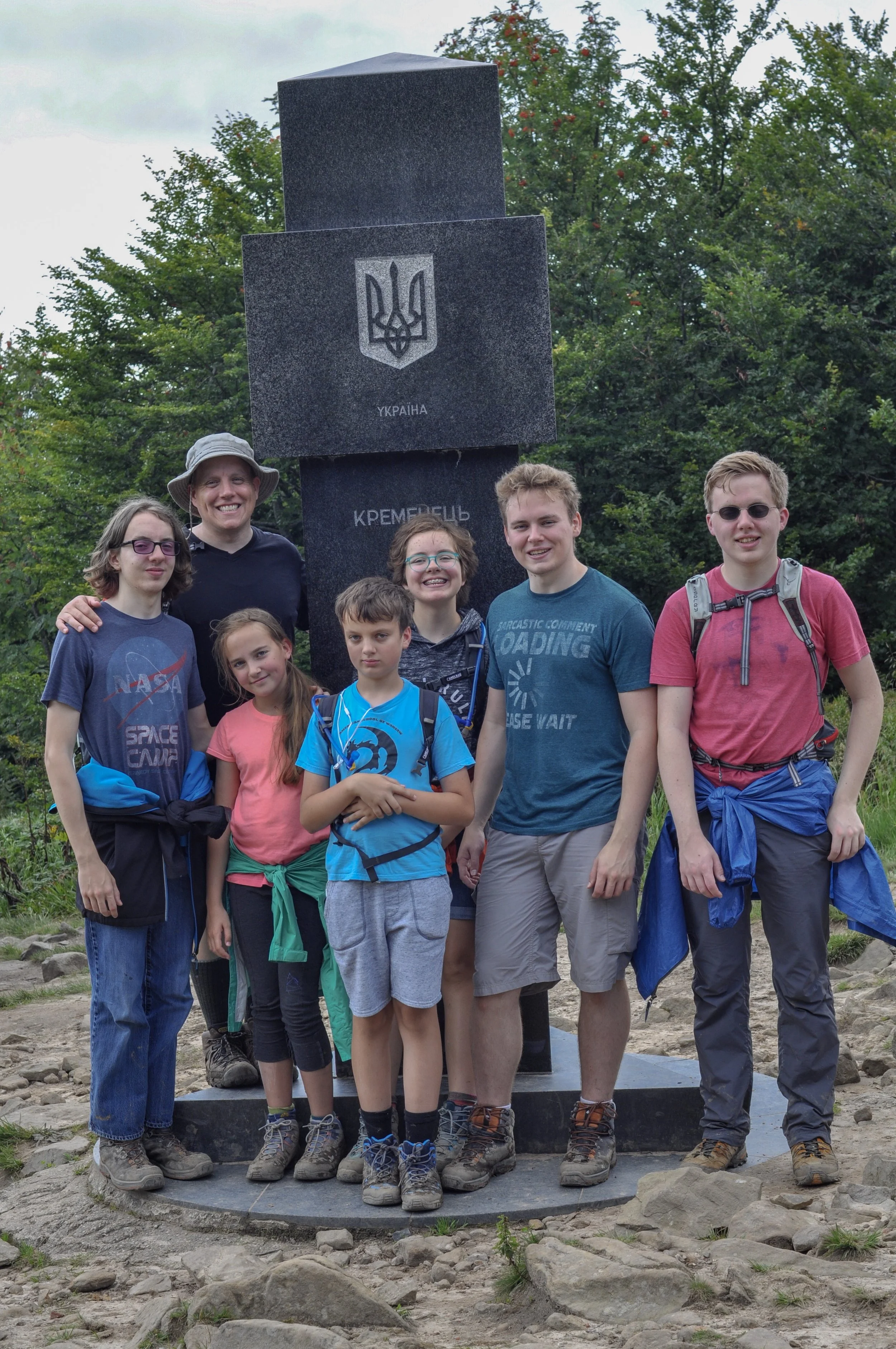 Hikers at the tri-border marker at the Poland-Ukraine-Slovakia border in the Bieszcady Mountains