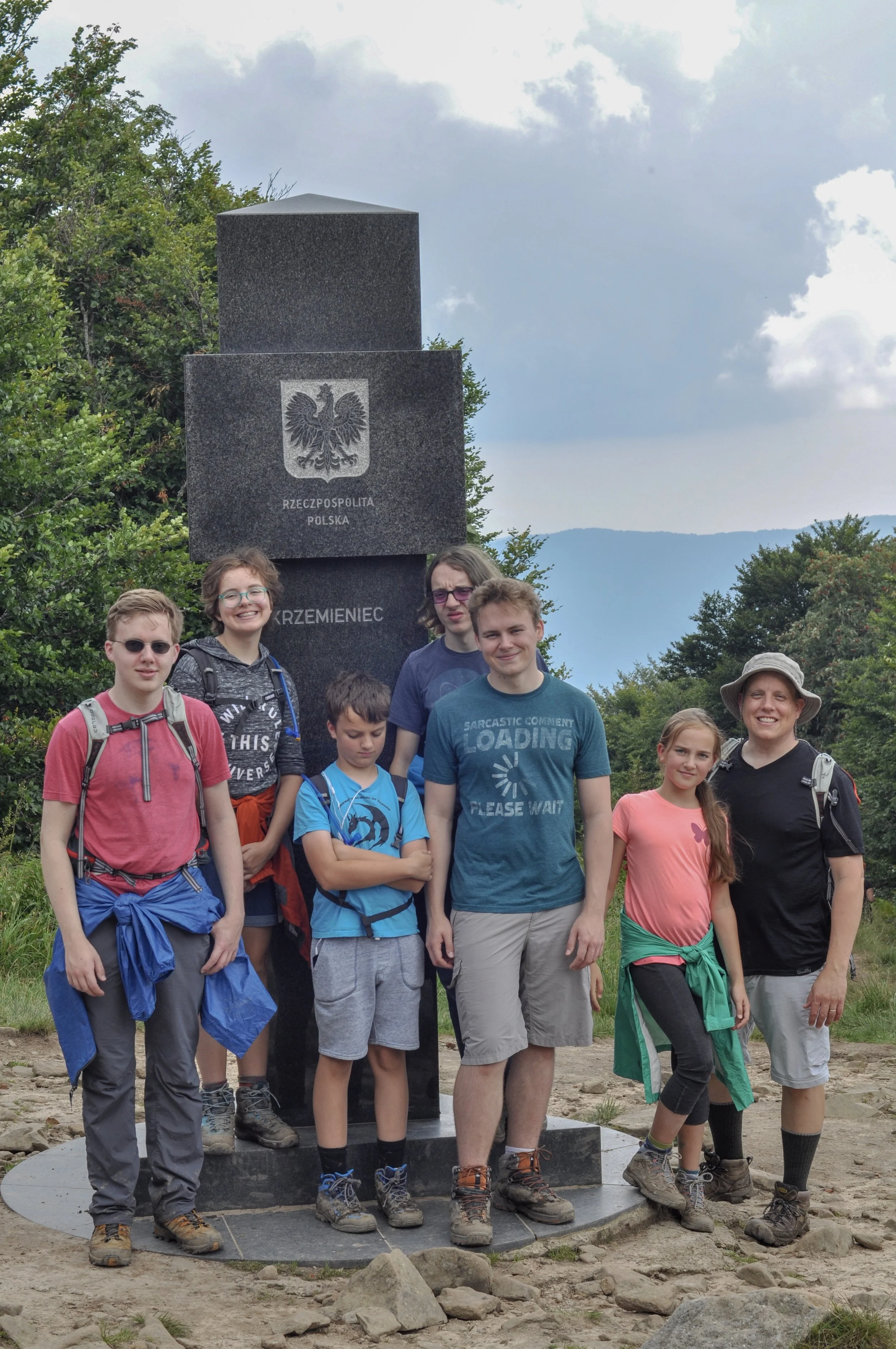 Hikers at the tri-border marker at the Poland-Ukraine-Slovakia border in the Bieszcady Mountains