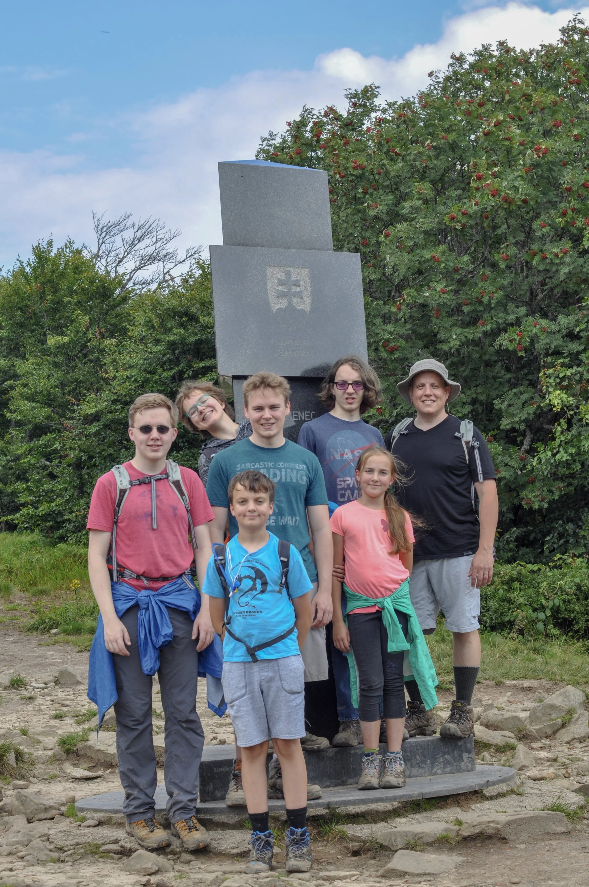 Hikers at the tri-border marker at the Poland-Ukraine-Slovakia border in the Bieszcady Mountains