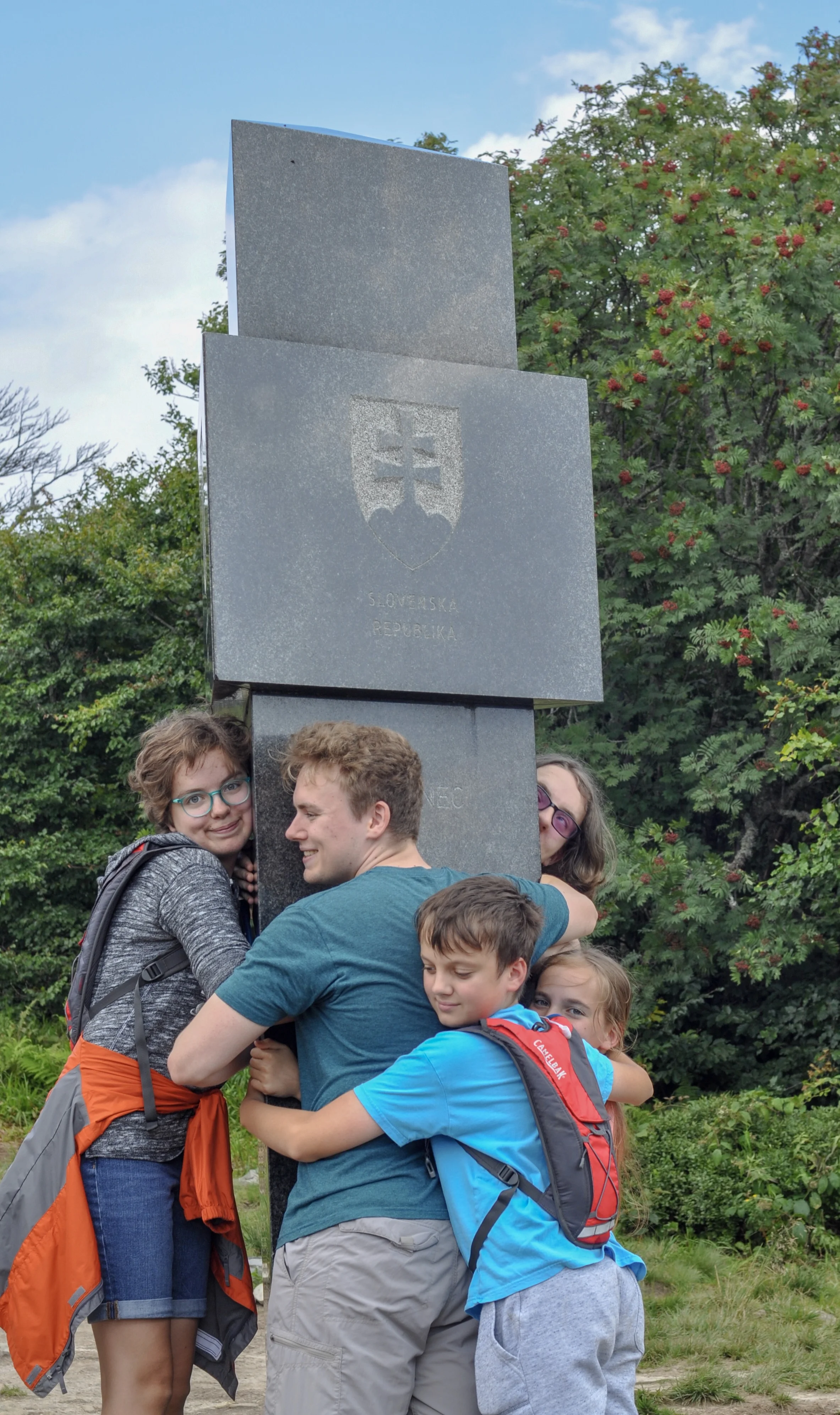Hikers at the tri-border marker at the Poland-Ukraine-Slovakia border in the Bieszcady Mountains