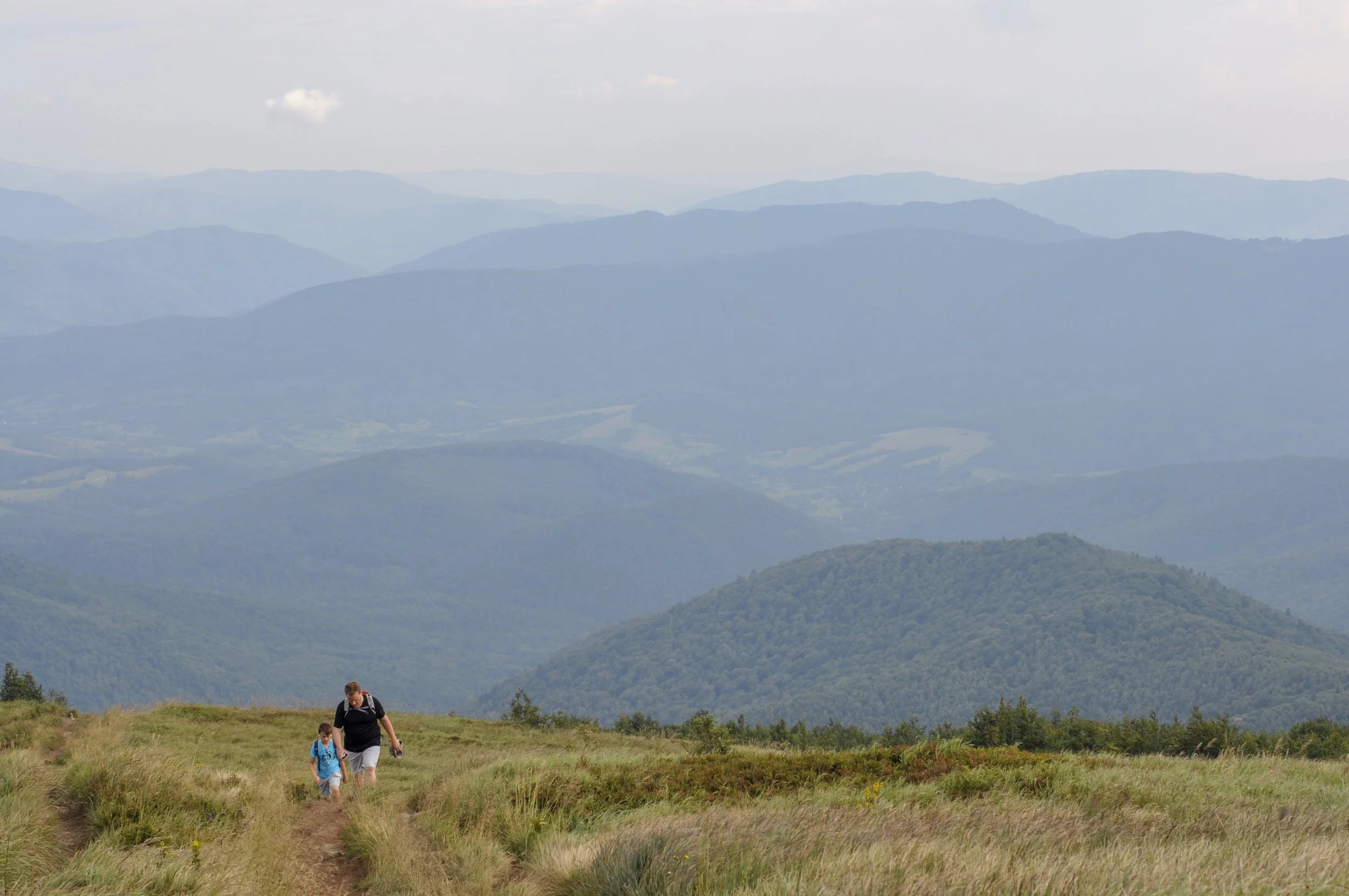 Two hikers walking through the połoniny on the Tri-Border hike in the Bieszcady Mountains
