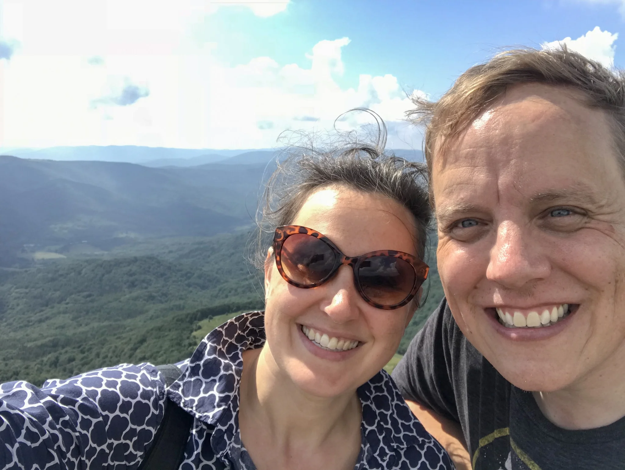 Two hikers with Bieszczady Mountains in the background.
