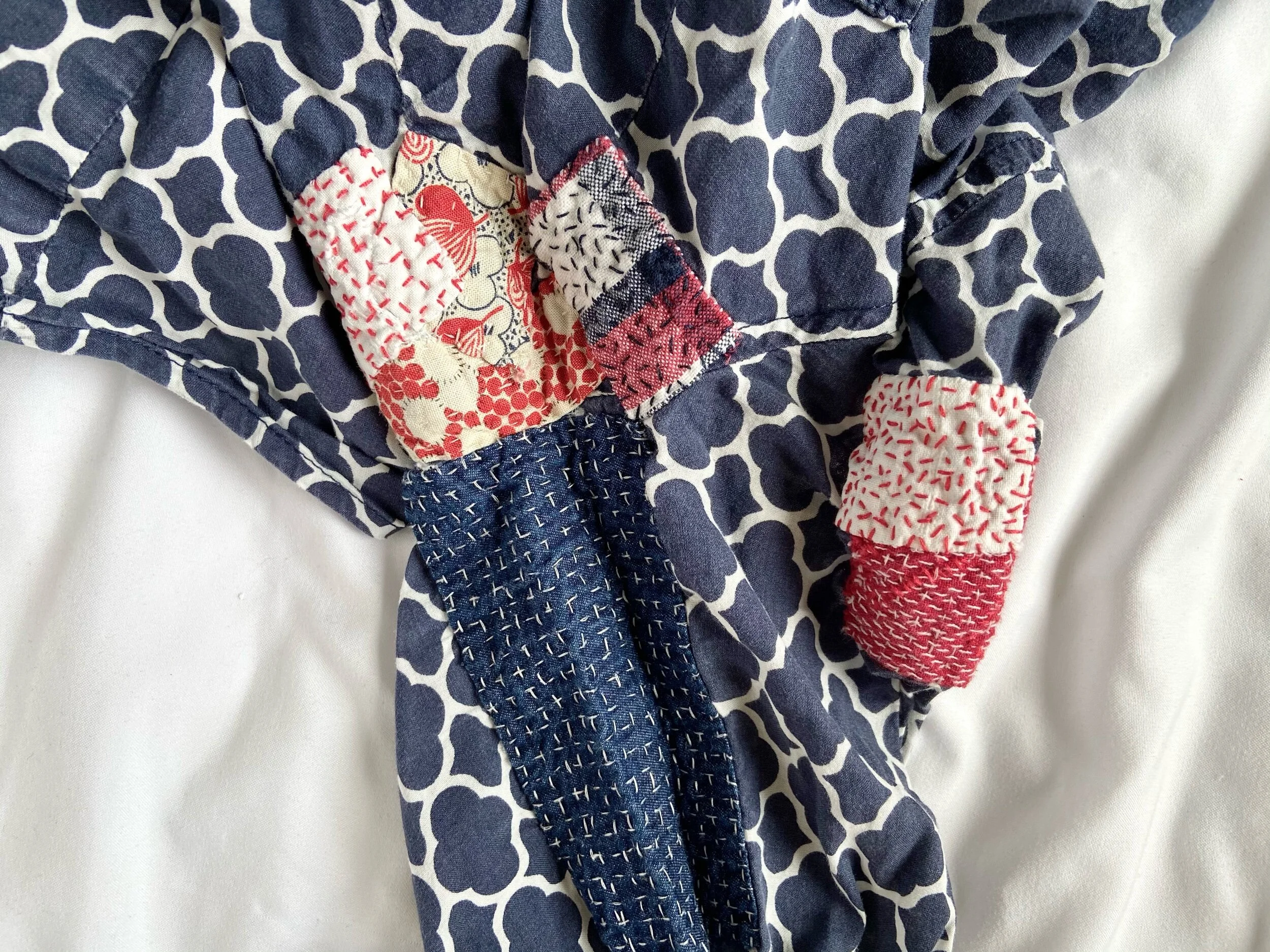 Blue and white shirt mended with many patches