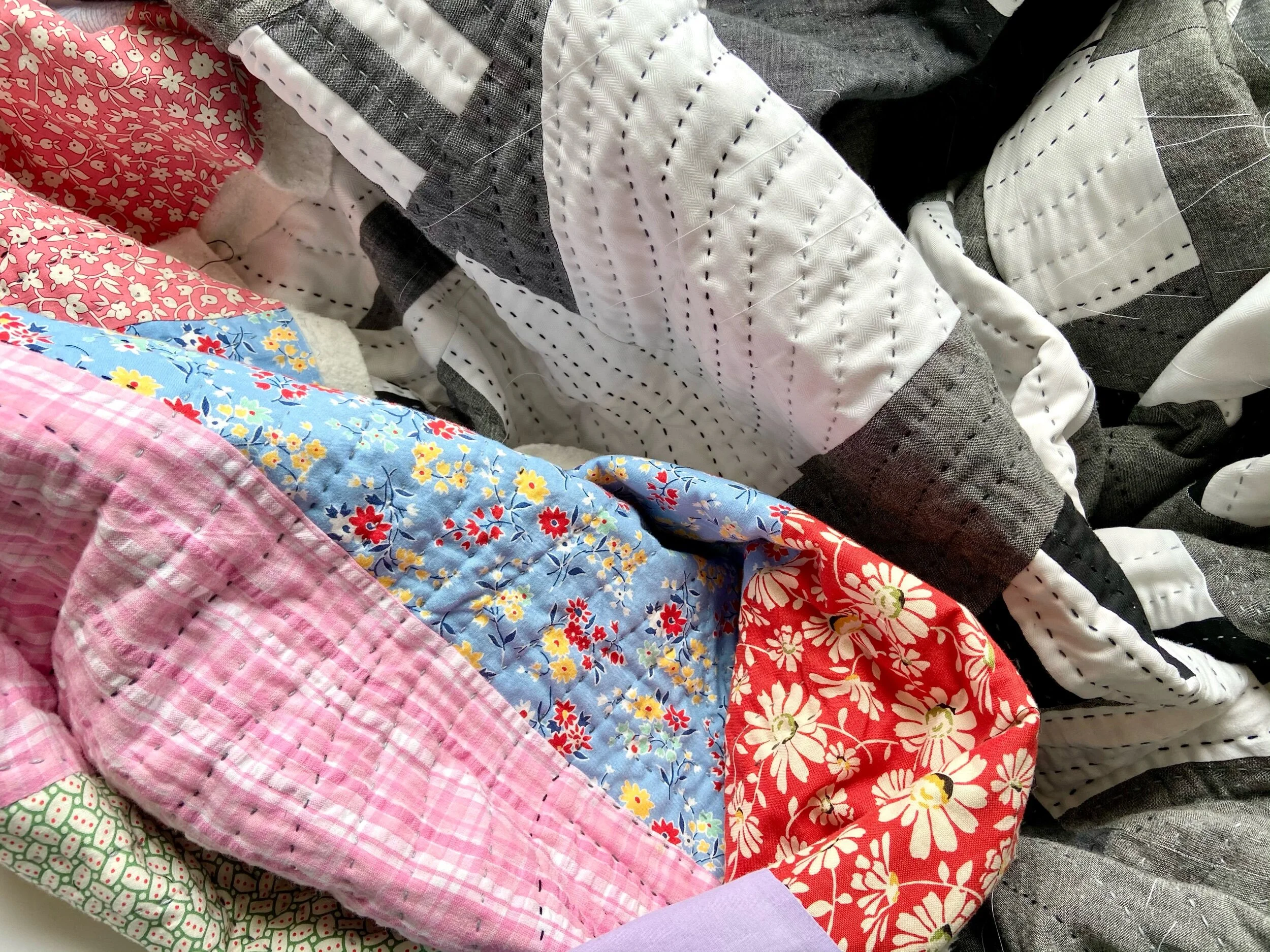 Multicolored quilt in process of being hand-quilted
