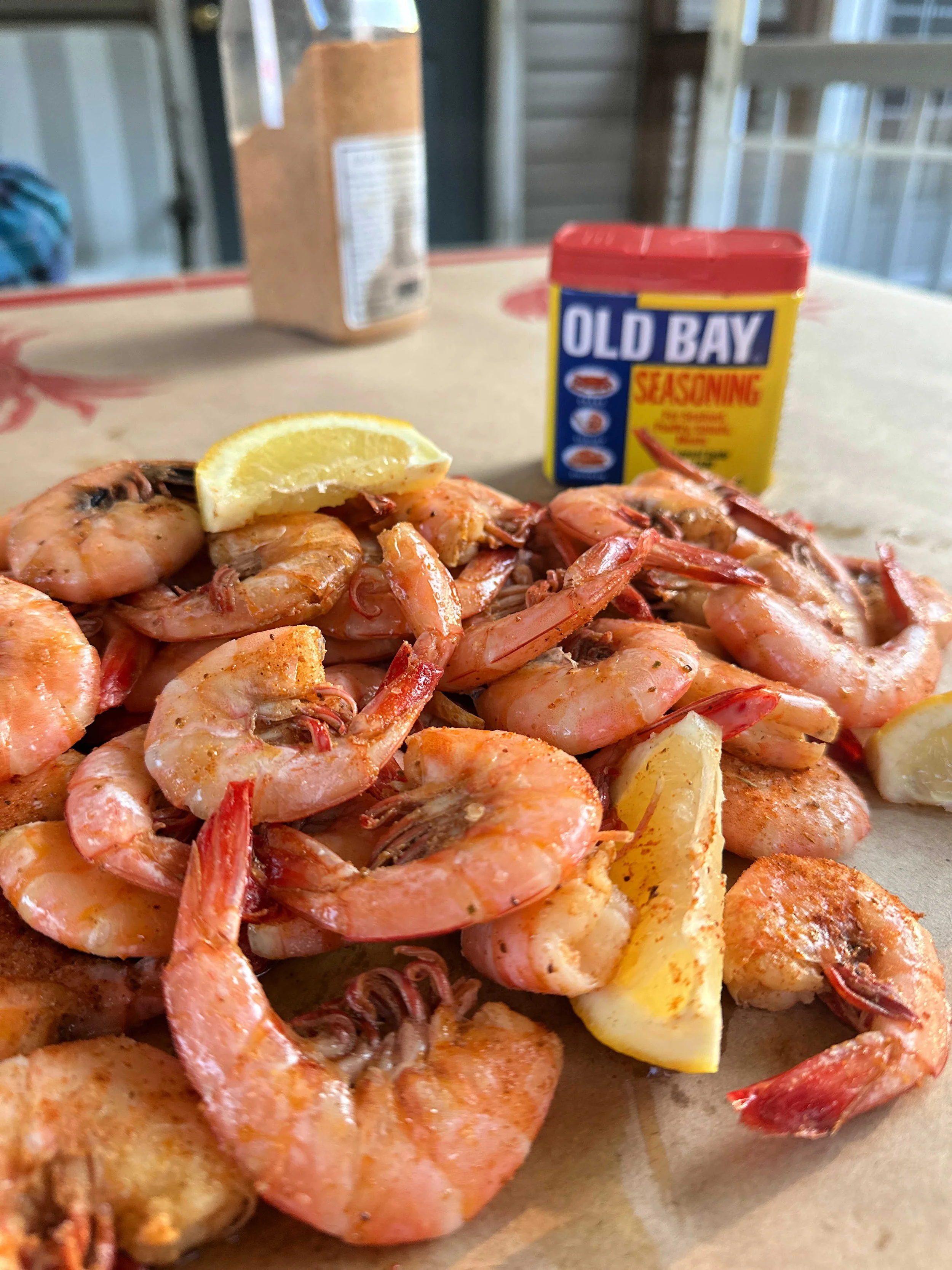 Beer boiled peel and eat shrimp with Old Bay seasoning on a serving platter with melted butter and lemon