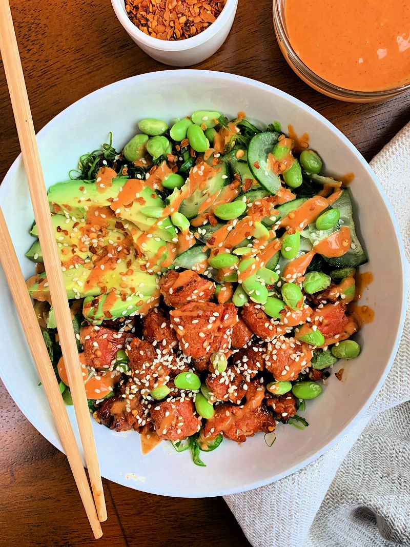 Honey sriracha salmon bowl with air fryer salmon bites, seaweed salad, edamame, cucumber, and spicy sriracha mayo drizzle