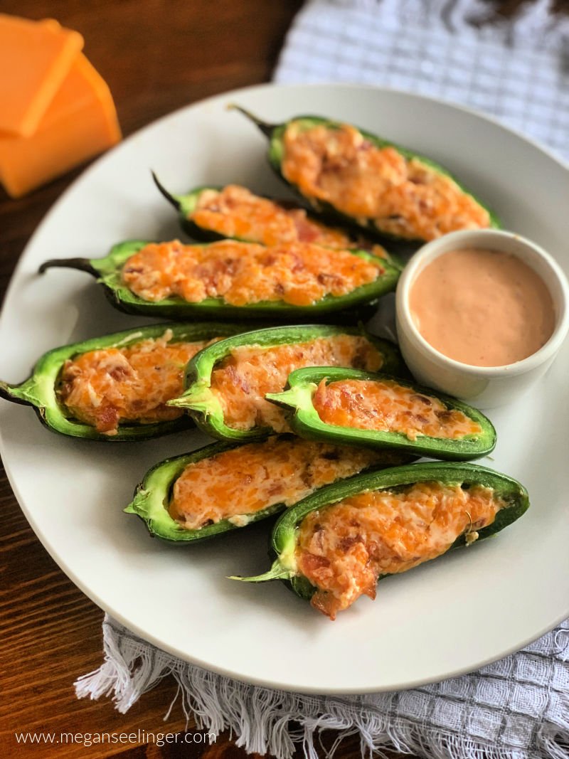 Easy jalapeño poppers with cream cheese cheddar filling and crispy bacon on a white serving plate