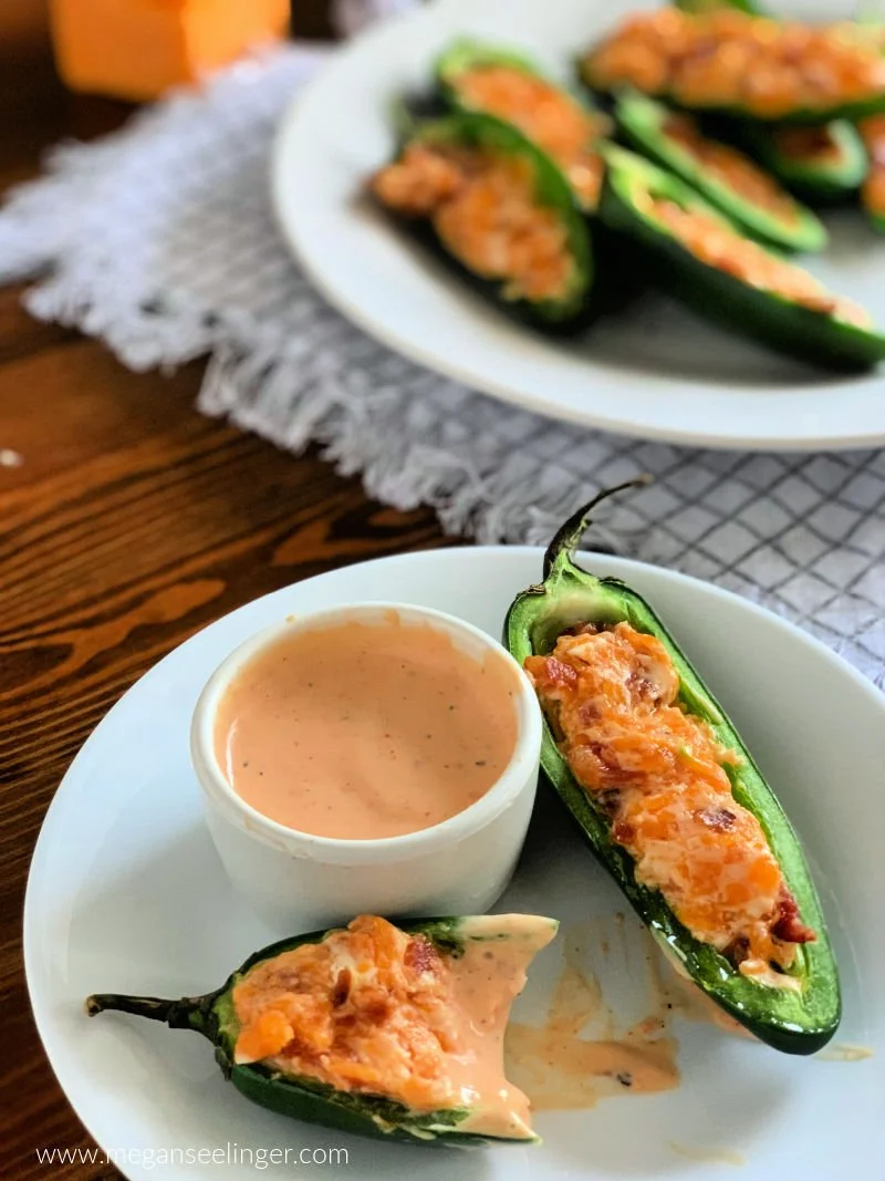 Easy jalapeño poppers with cream cheese cheddar filling and crispy bacon on a white serving plate