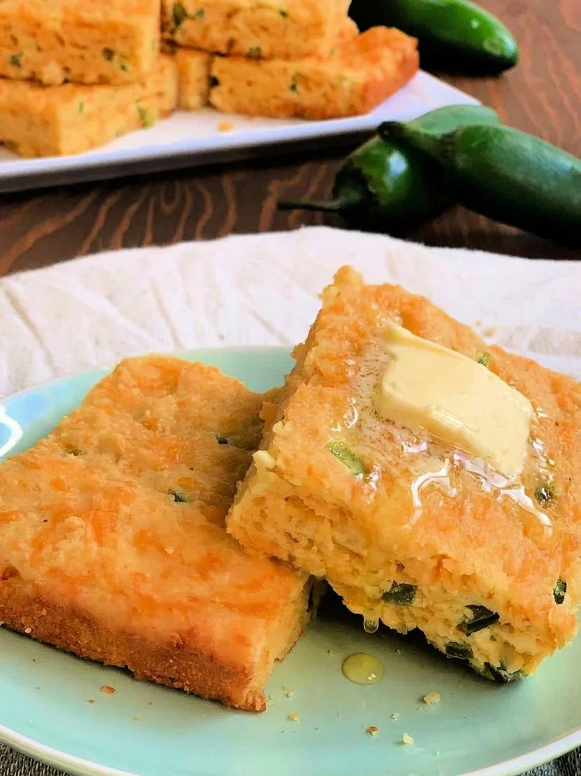 Jalapeño cheddar almond flour cornbread sliced in a 9x13 baking dish showing cheesy interior and golden top with visible jalapeño pieces