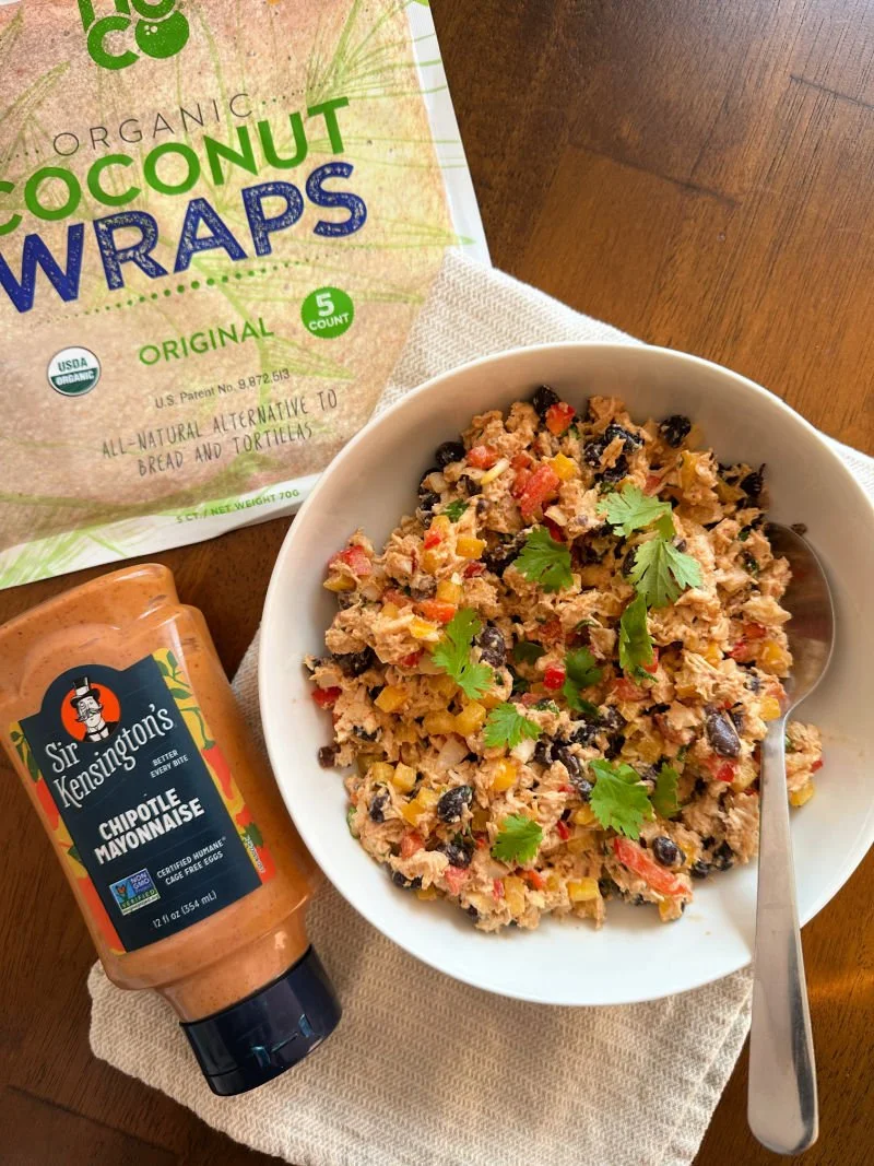 Southwest chipotle chicken salad in a bowl with red and yellow bell peppers, black beans, tomato, red onion, and cilantro