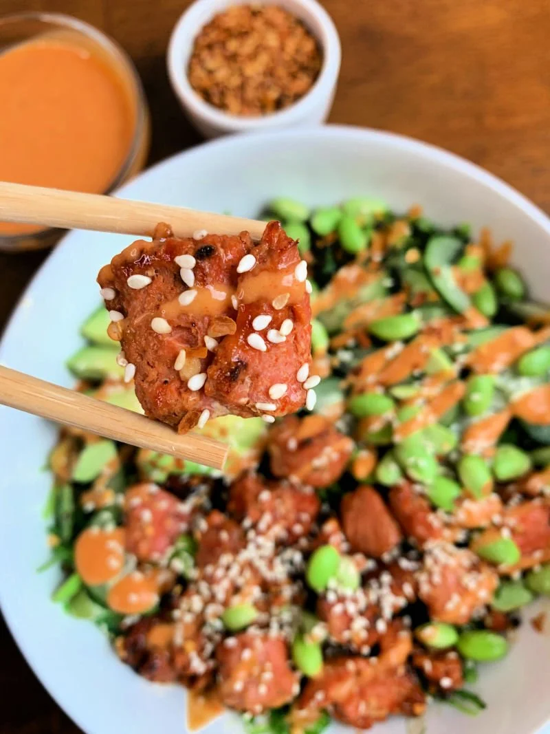 Honey sriracha salmon bowl with air fryer salmon bites, seaweed salad, edamame, cucumber, and spicy sriracha mayo drizzle