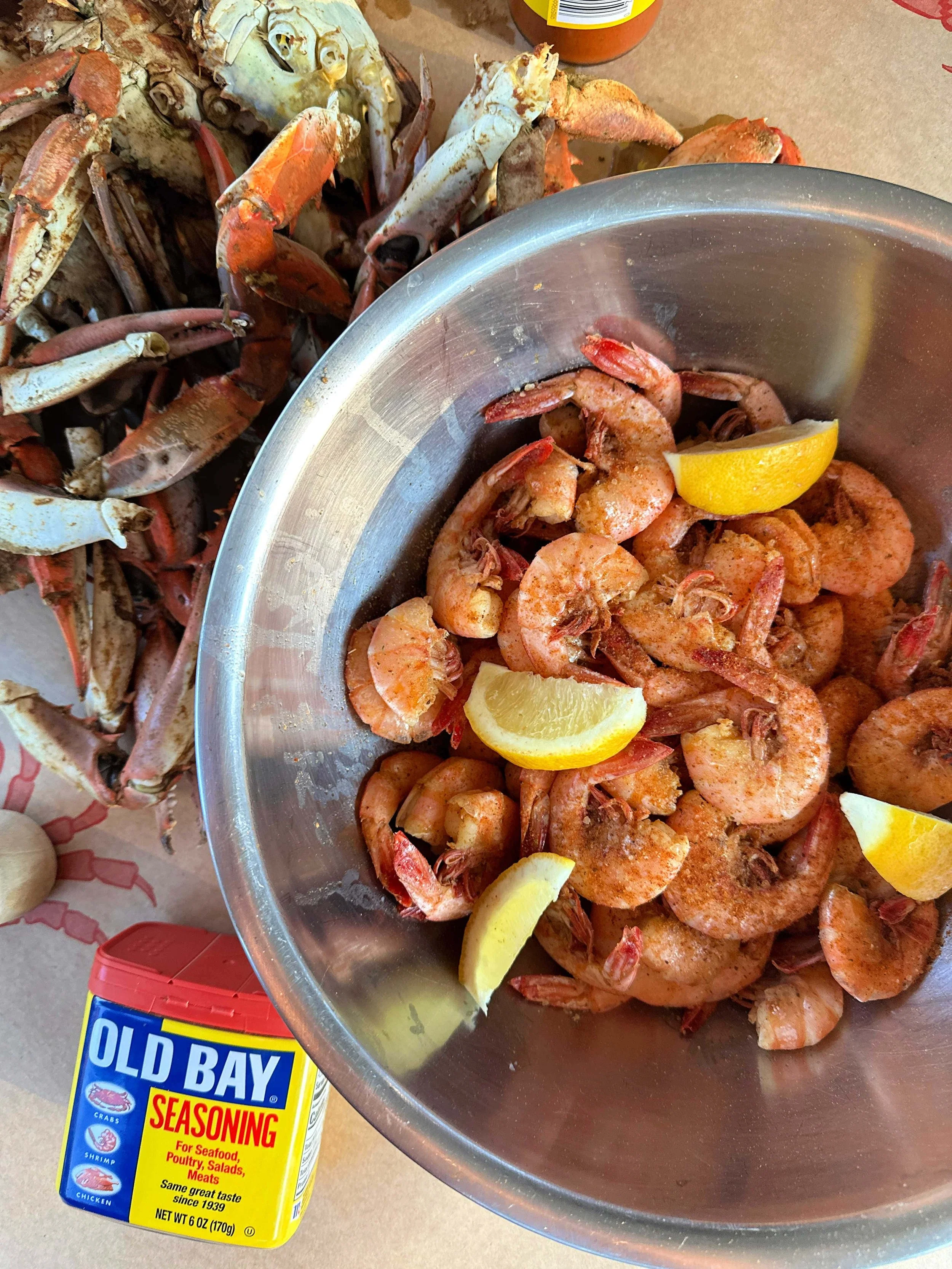 Beer boiled peel and eat shrimp with Old Bay seasoning on a serving platter with melted butter and lemon