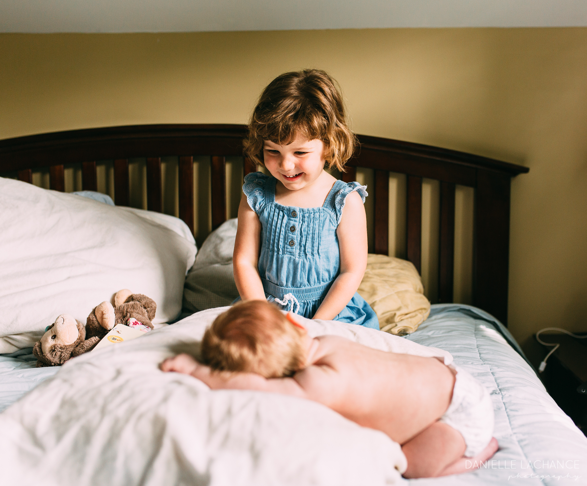big sister looking at her new baby sibling photography