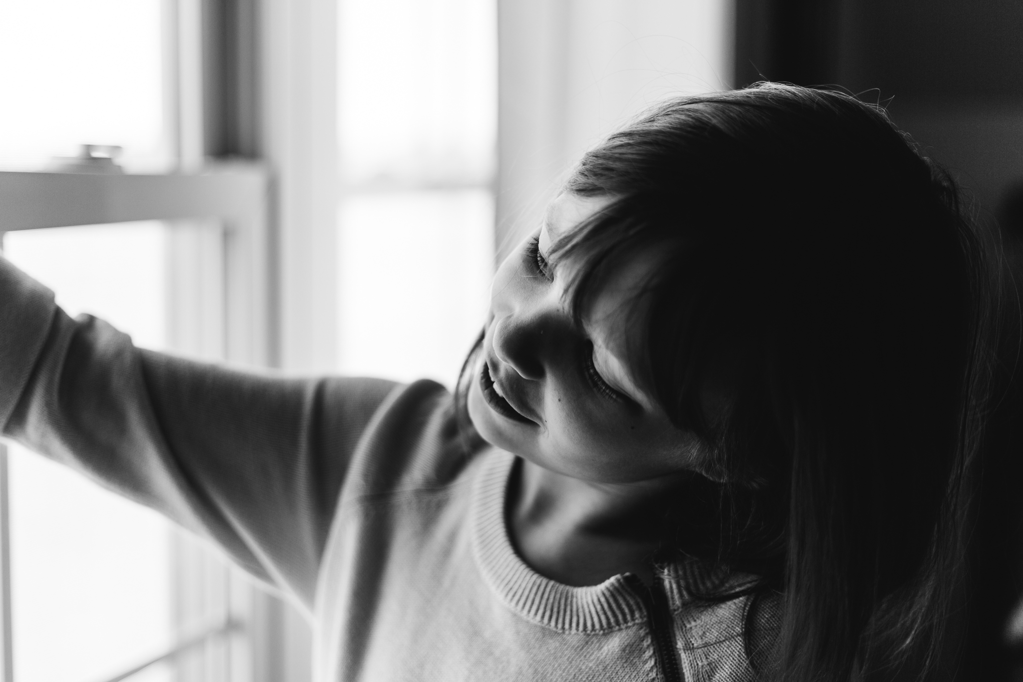 black and white of girl looking out window
